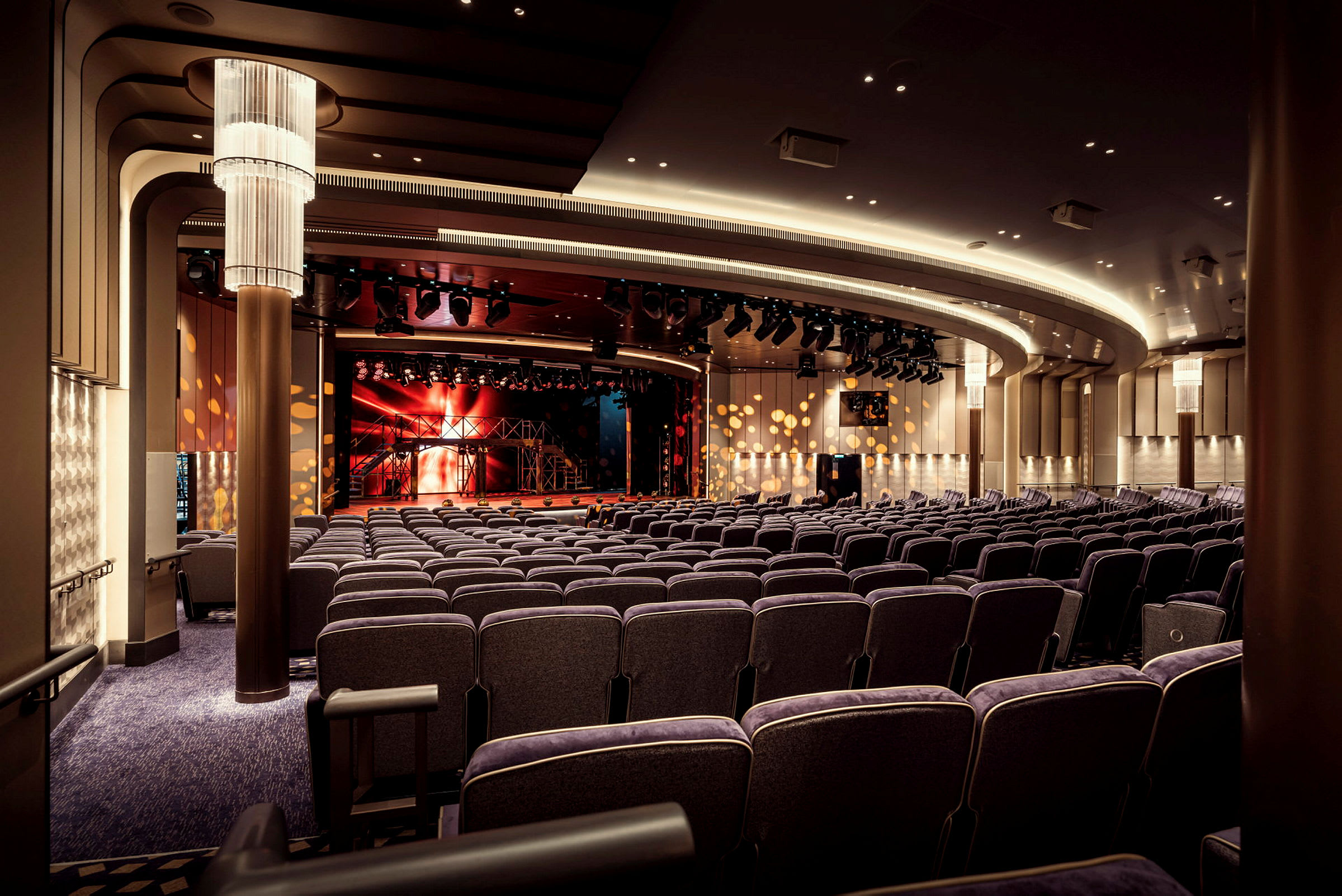 En stor teater med många stolar och en belyst scen. (AI-genererad text)