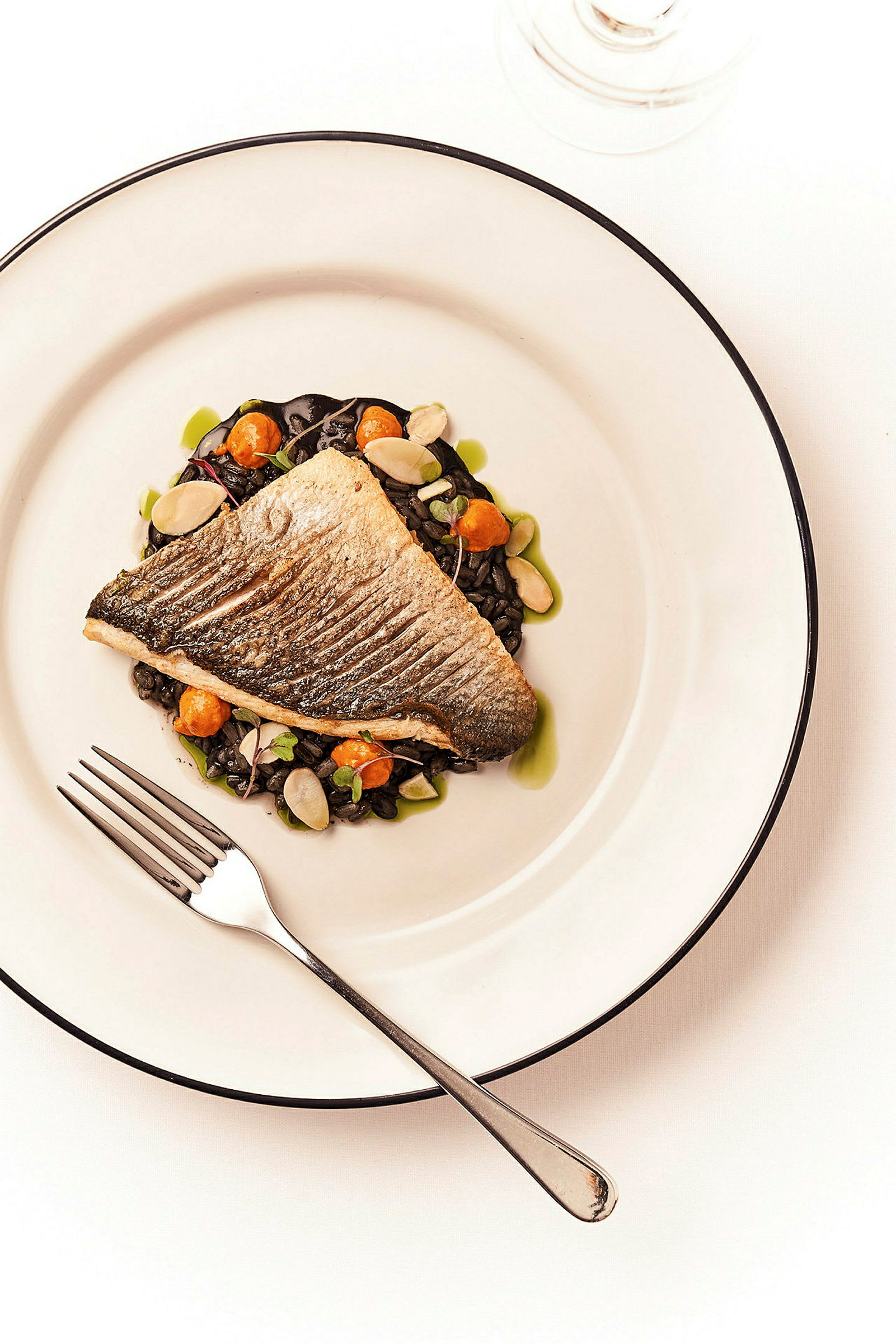 En servering av grillad fisk med tillbehör på en tallrik. (AI-genererad text)