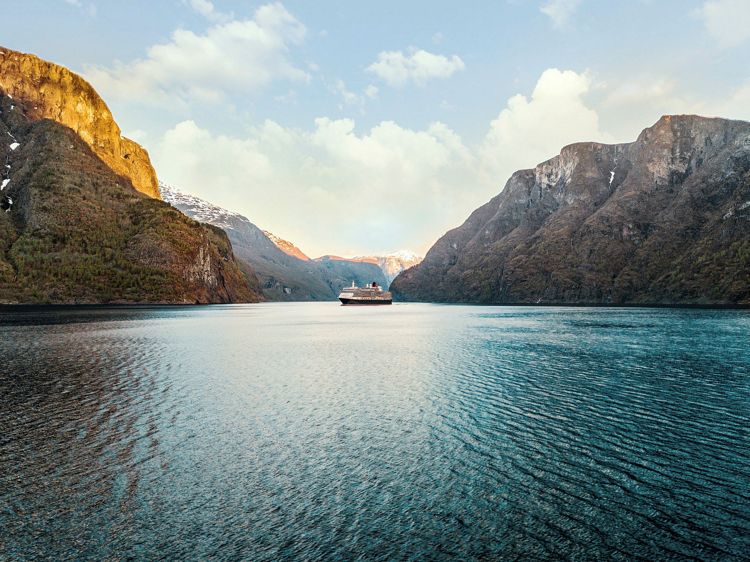 En båt färdas genom en fjord omgiven av berg. (AI-genererad text)