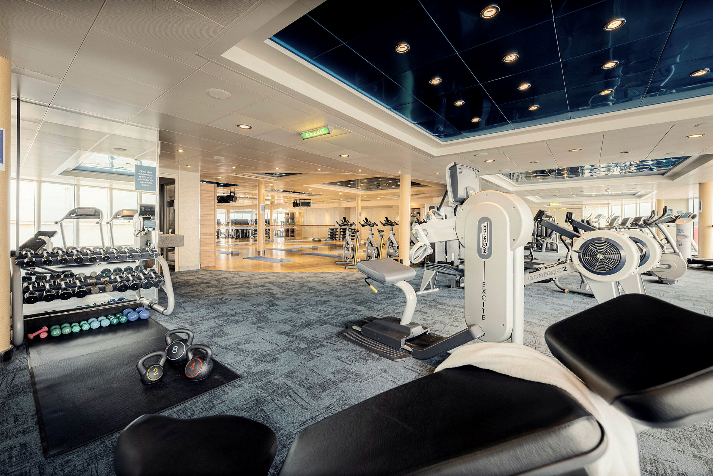 Ett gym med träningsmaskiner, hantlar och cyklar. (AI-genererad text)