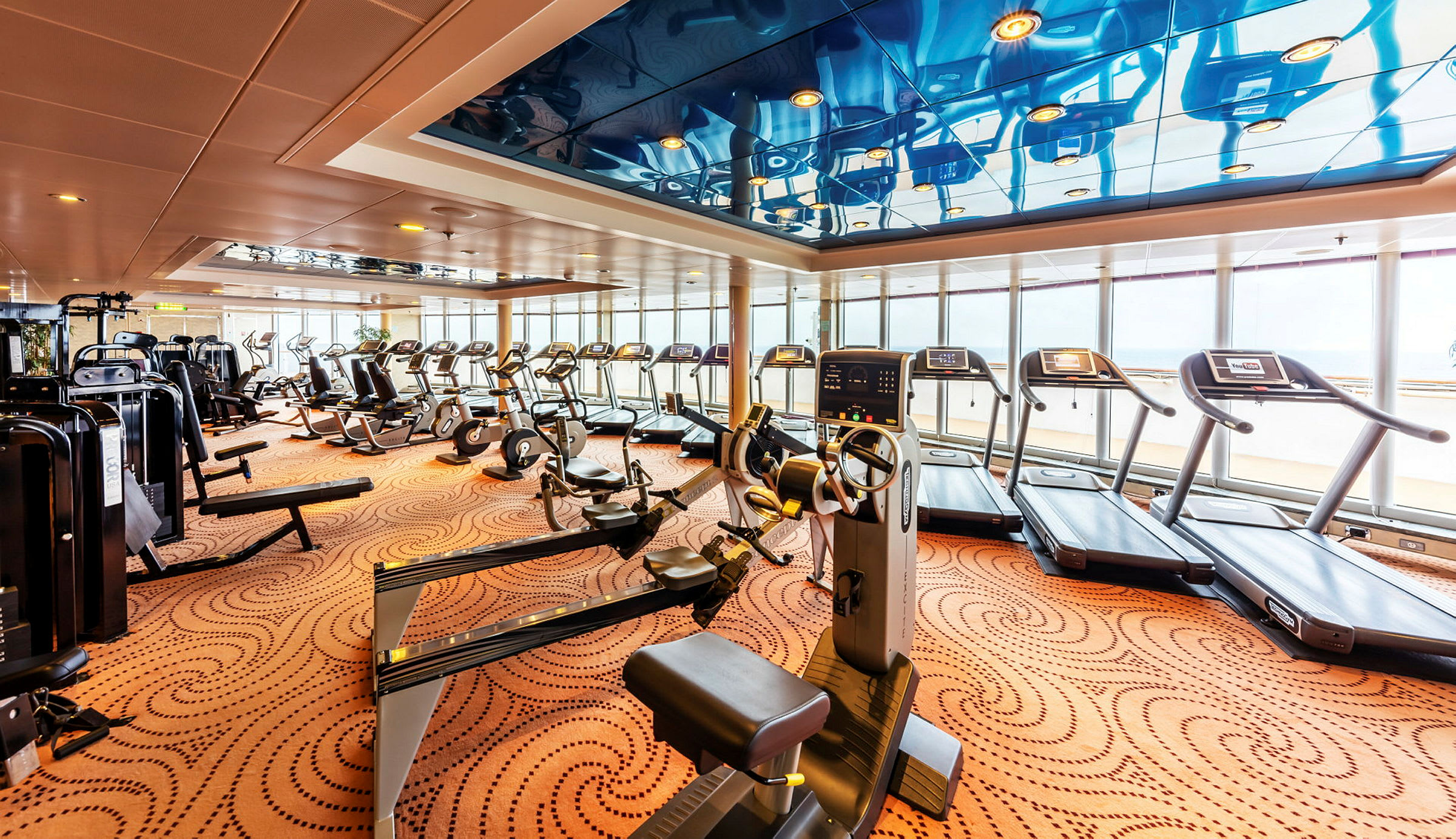 Gym med träningsmaskiner och löpband. (AI-genererad text)