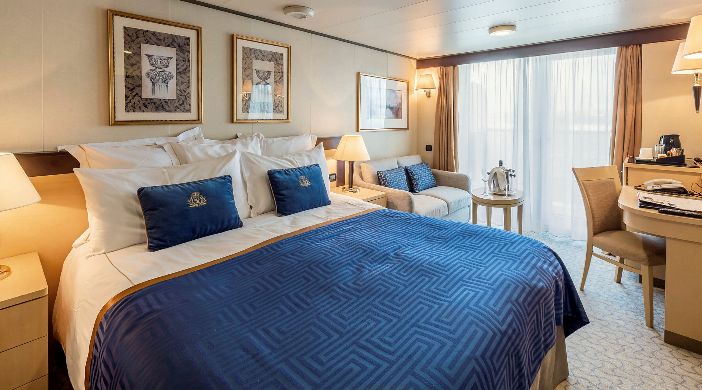 Hotellrum med dubbelsäng, soffa, skrivbord och stora fönster. (AI-genererad text)