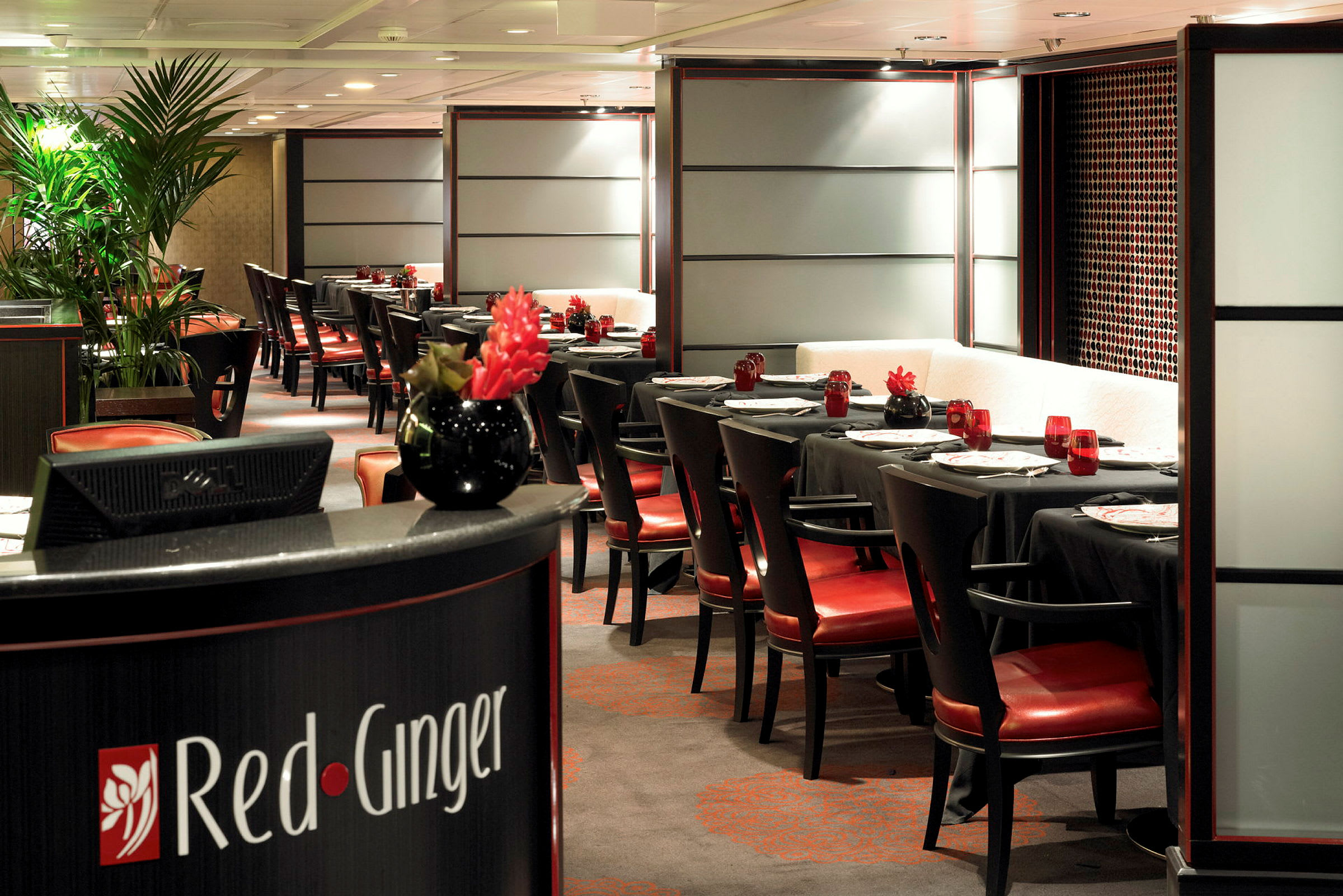 En elegant restaurang med dukade bord, röda stolar och dekorativa växter. (AI-genererad text)