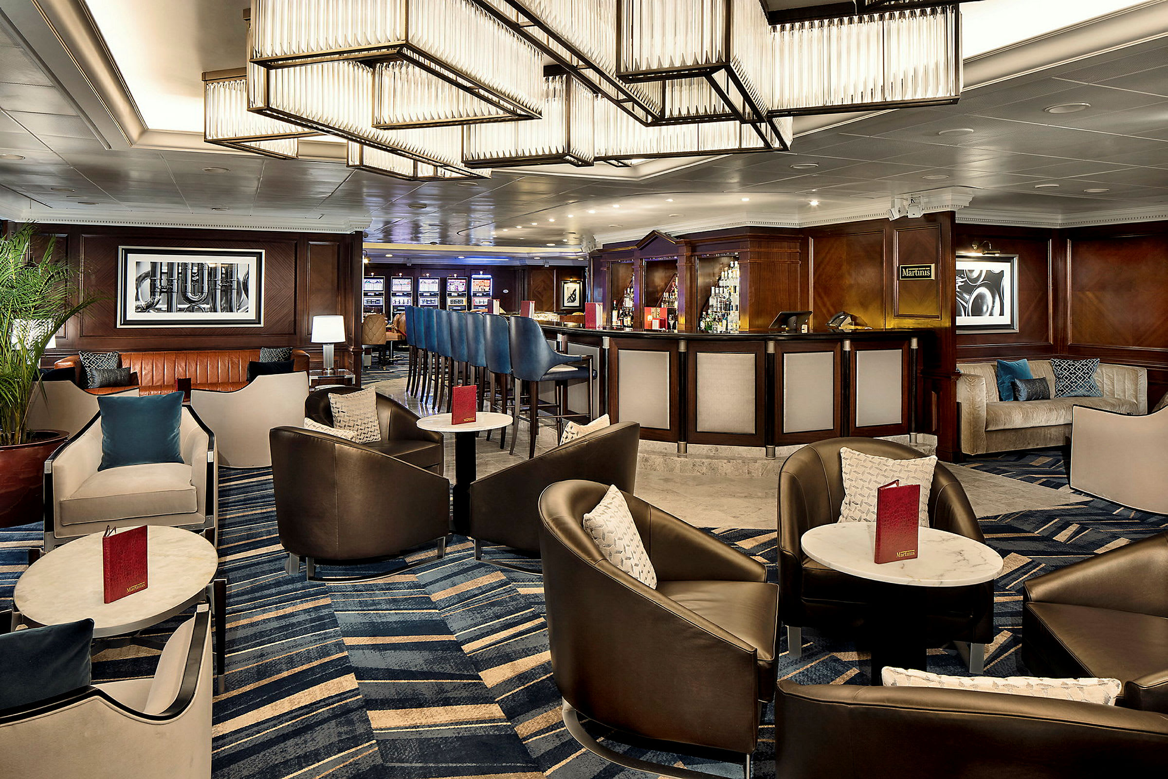 En elegant hotellbar med sitsgrupper, moderna ljuskronor och en lång bardisk. (AI-genererad text)