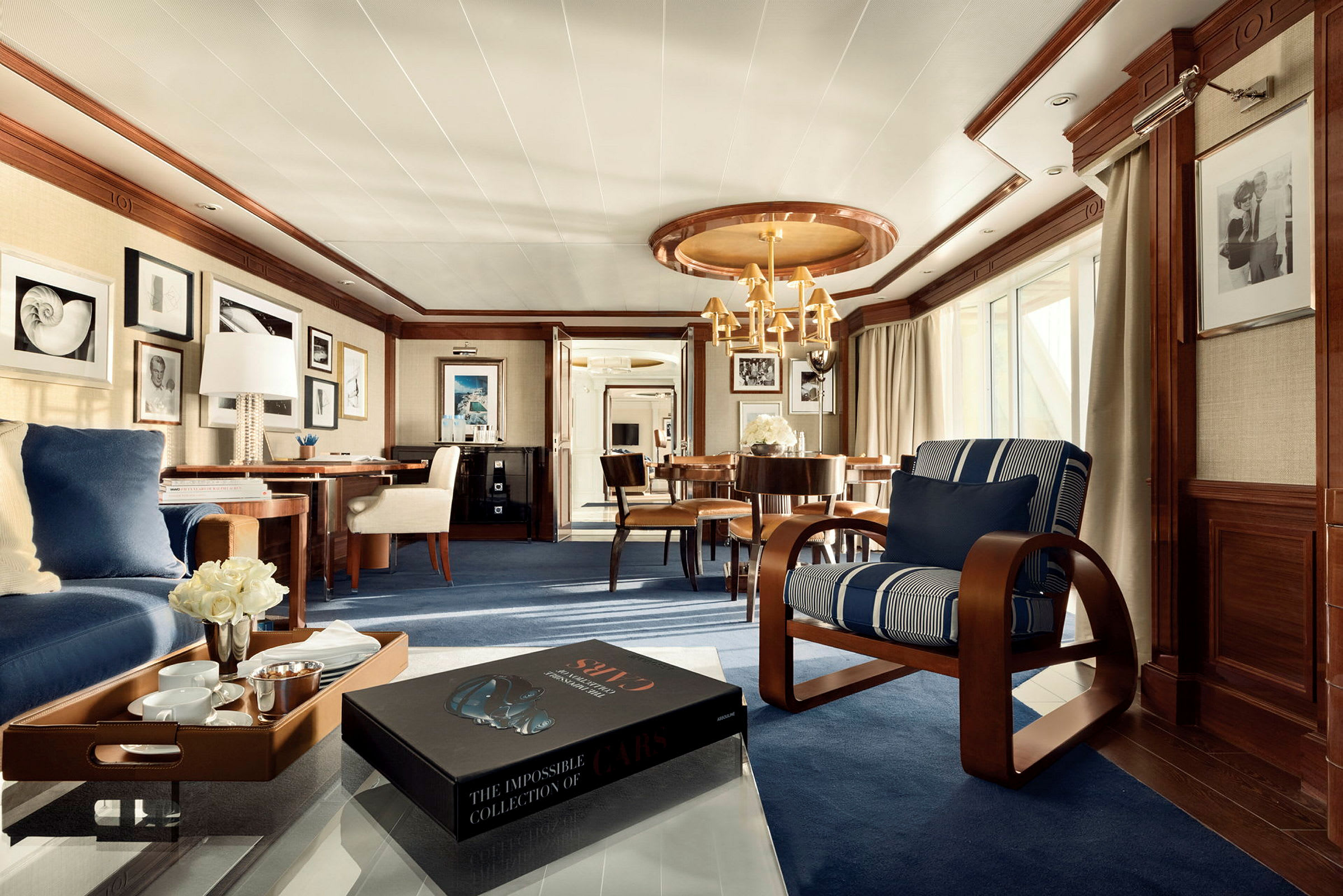 Ett elegant och rymligt vardagsrum i en hotellsvit med en bekväm sittgrupp, ett bord med inredning och en bok på glasbordet. (AI-genererad text)