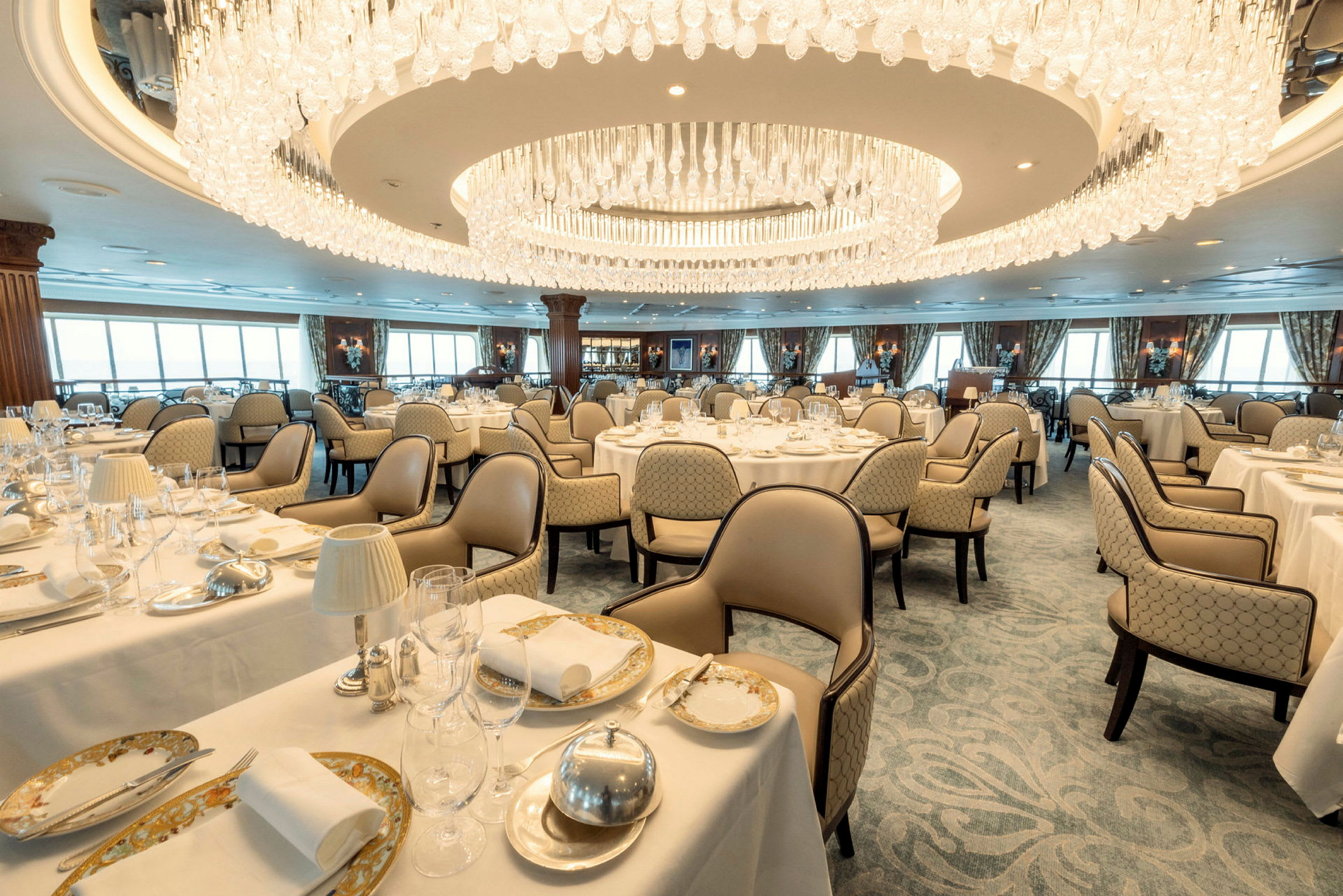 Ett elegant restaurangrum med dukade bord och en stor kristallkrona. (AI-genererad text)