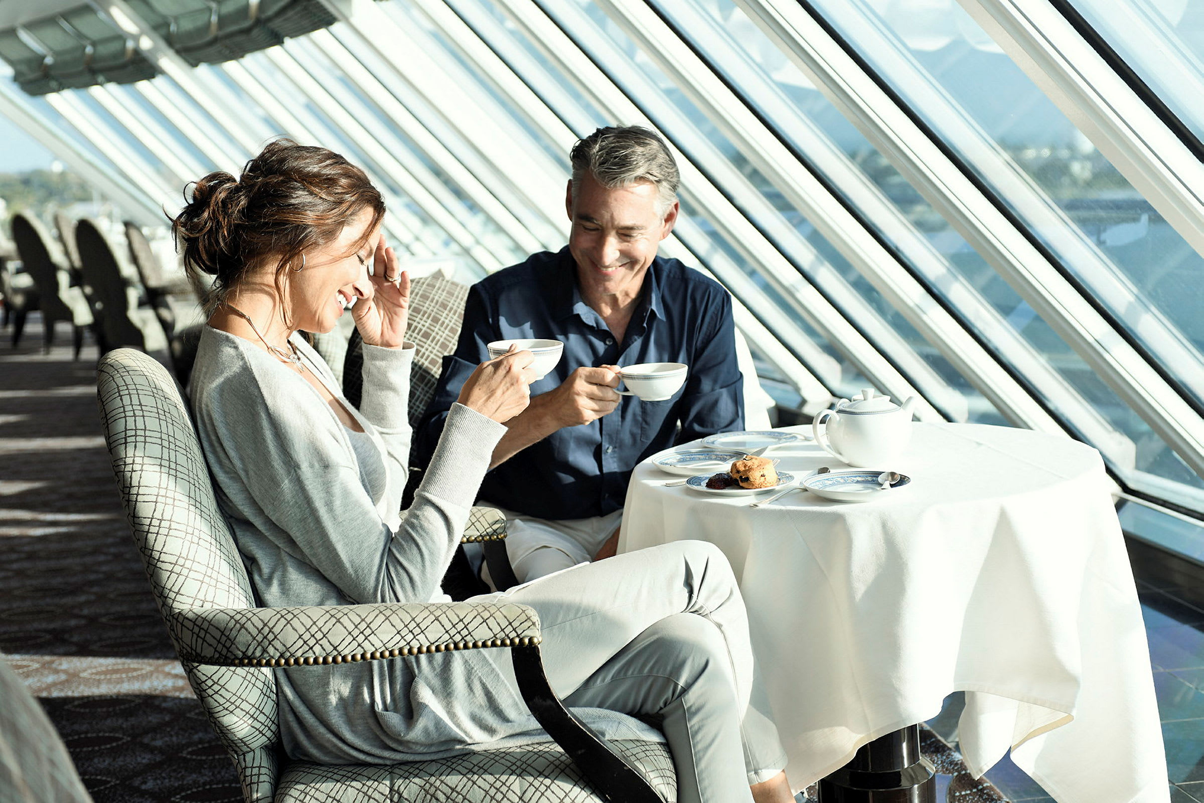 Två personer sitter vid ett bord och dricker kaffe i en ljus miljö. (AI-genererad text)