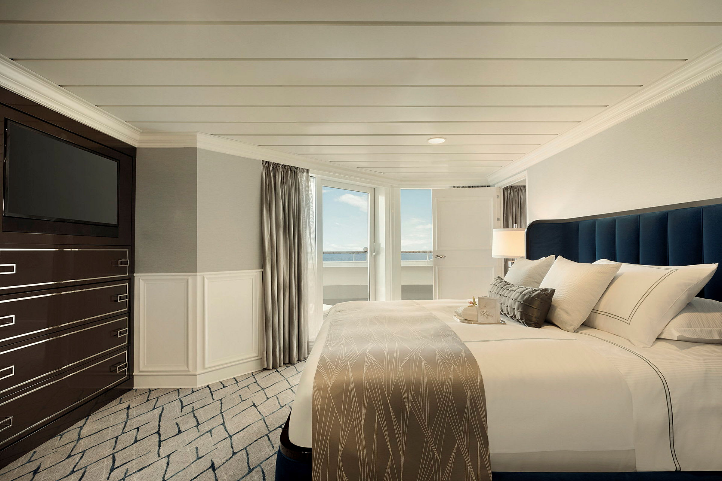 Ett elegant hotellrum med en stor säng, TV på väggen och en balkong med utsikt. (AI-genererad text)