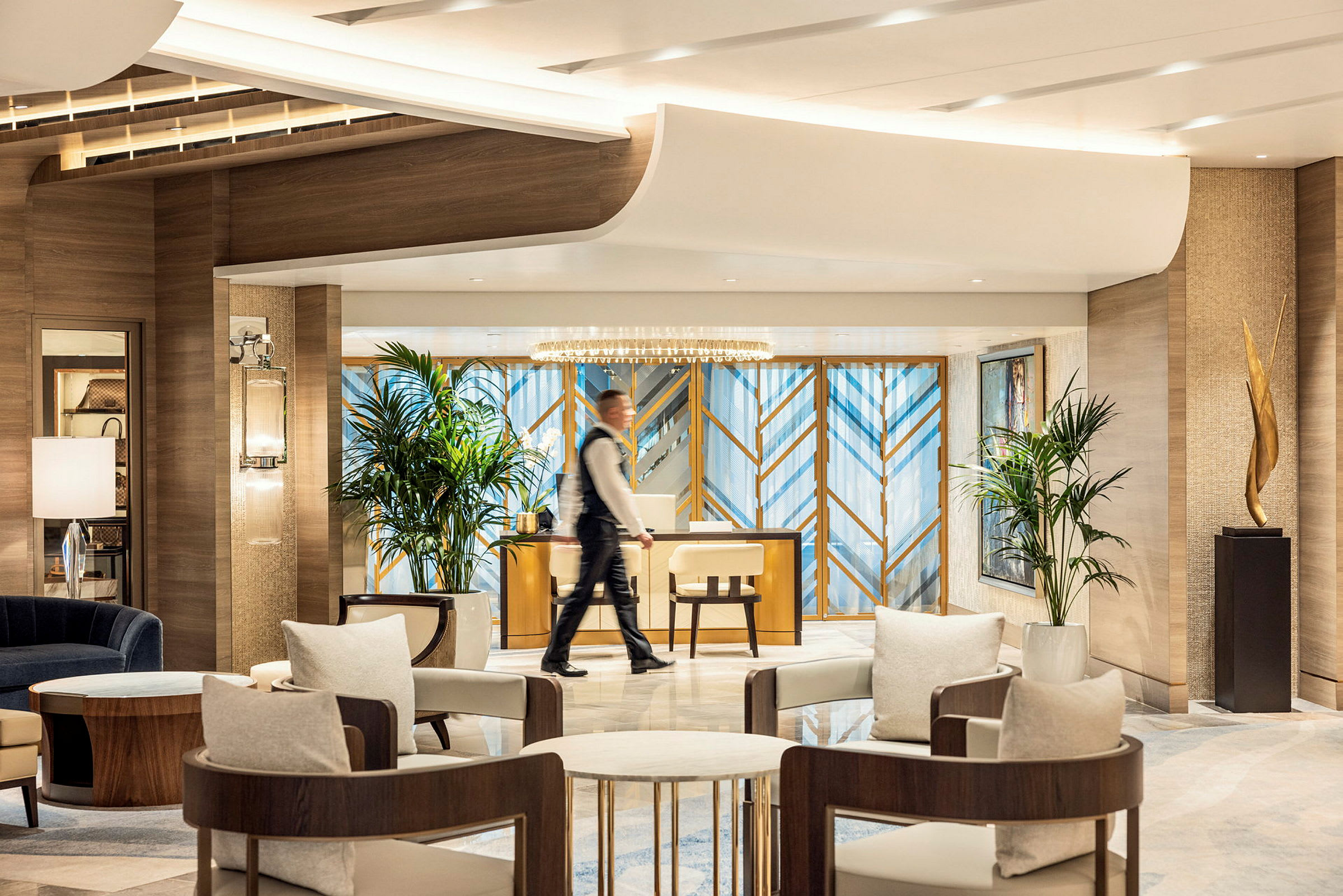Ett modernt hotellobby med sittgrupper, dekorativa växter och en receptionsdisk. (AI-genererad text)