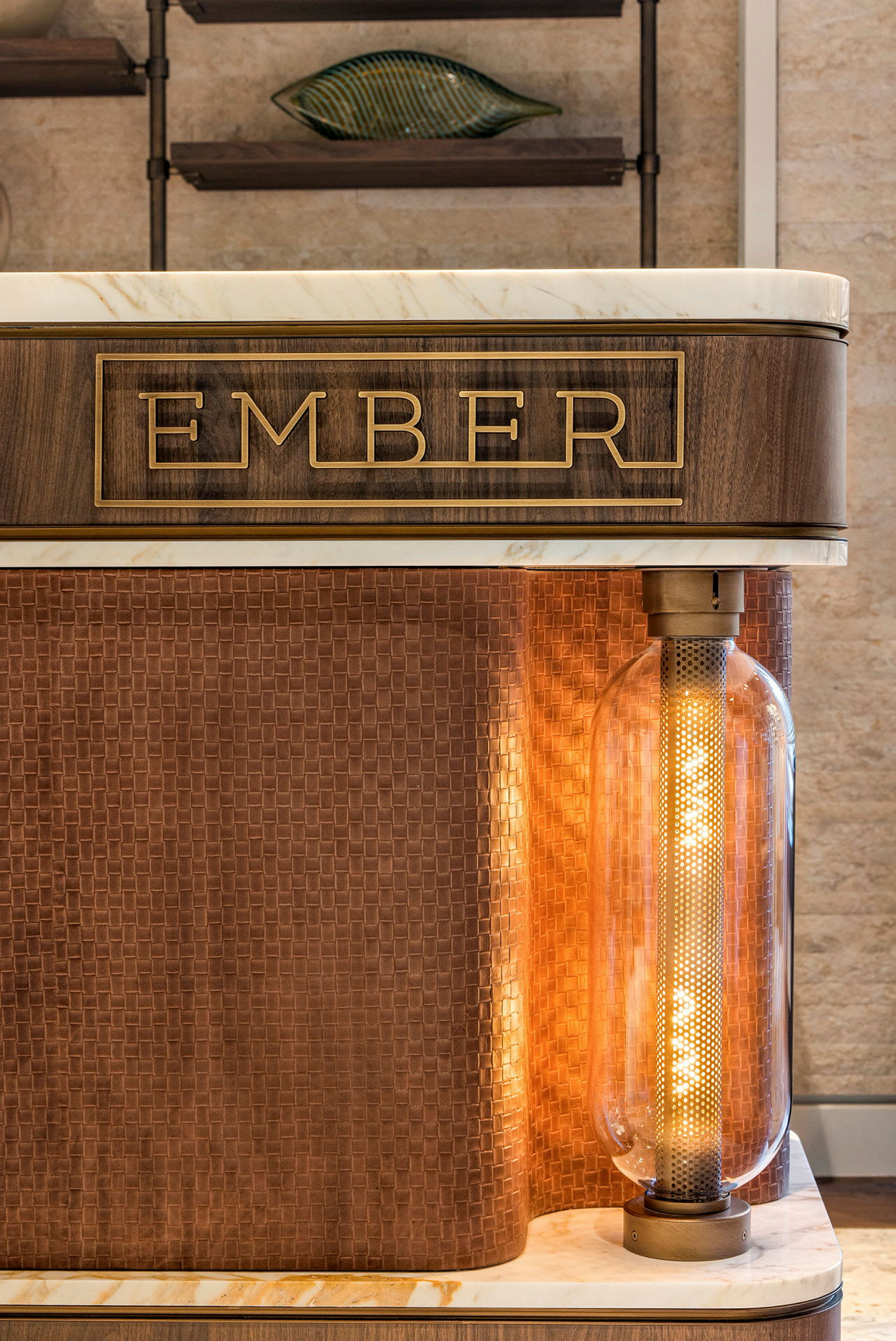 Detalj av en möbel med texten 'EMBER' och belyst designelement. (AI-genererad text)