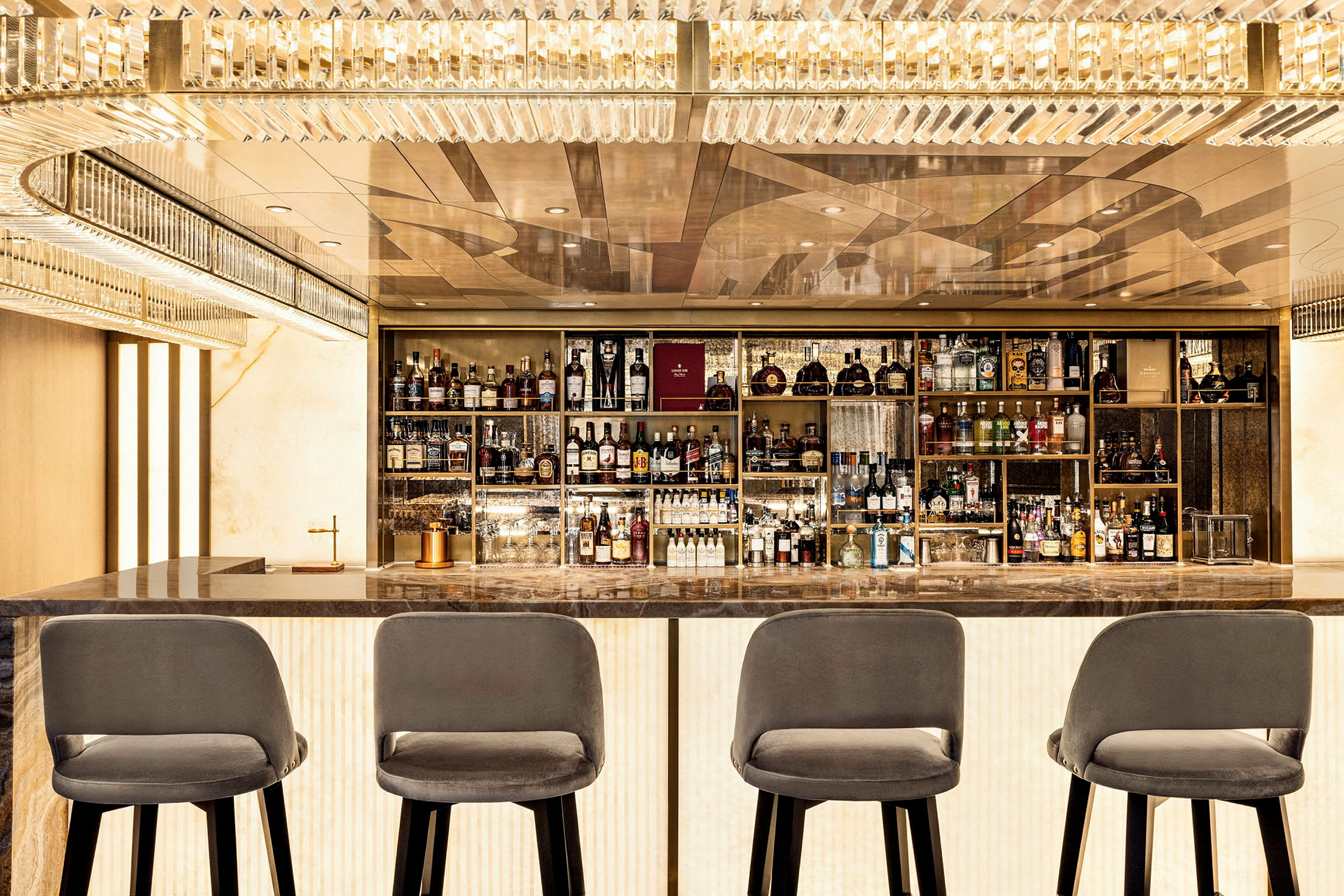 En bar med fyra sittplatser framför hyllor fyllda med flaskor. (AI-genererad text)