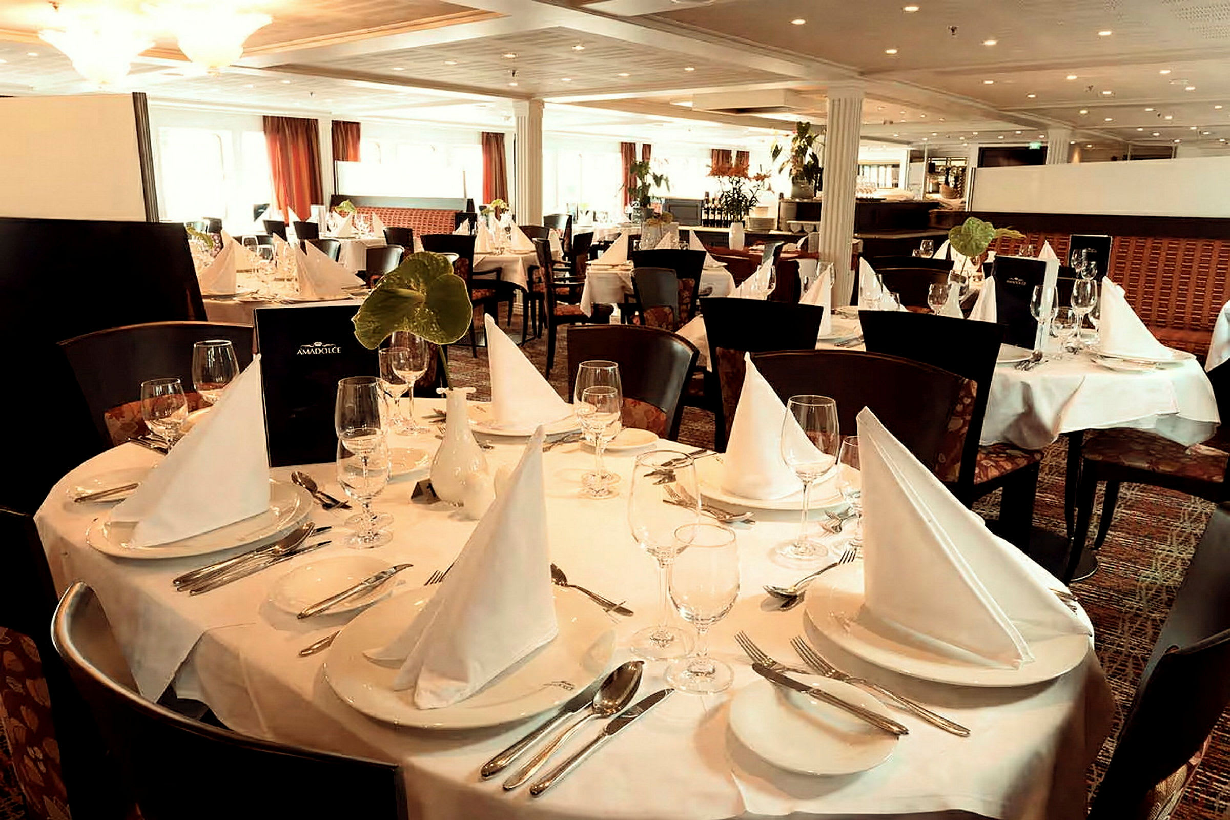 Ett elegant restaurangområde med dukade bord och vita servetter. (AI-genererad text)