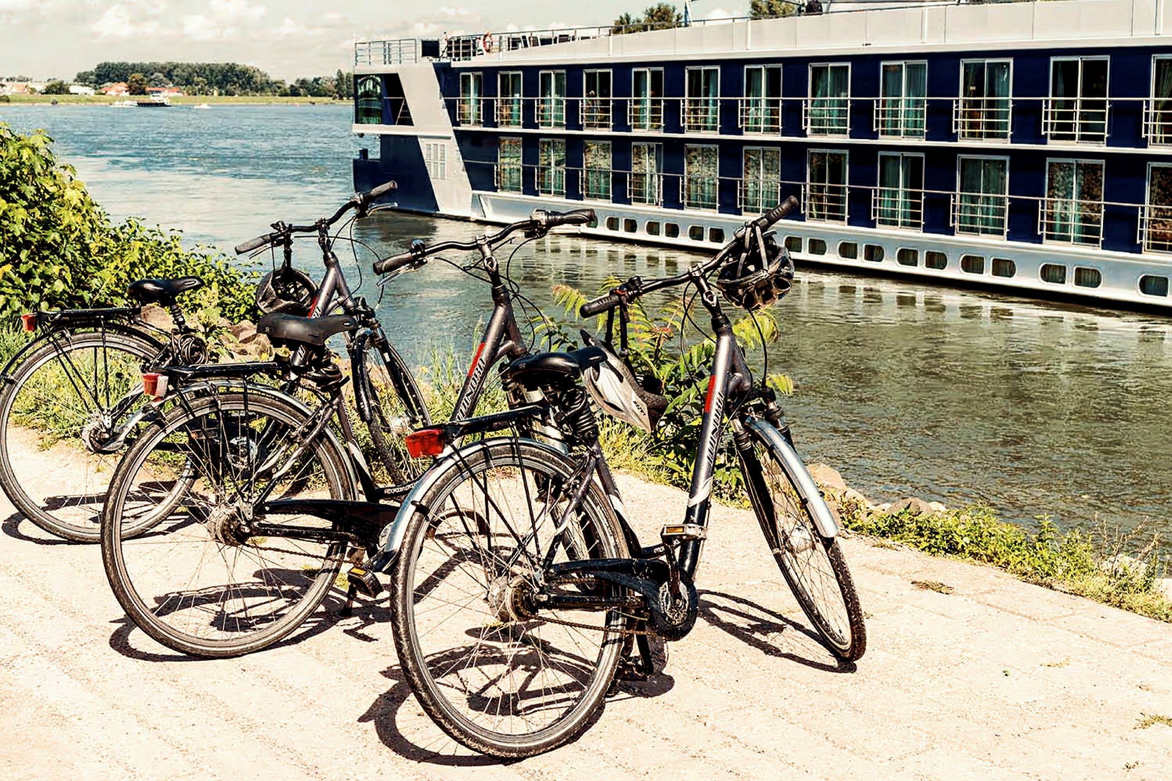 Cyklar står parkerade vid en kaj bredvid en flodcruisebåt. (AI-genererad text)