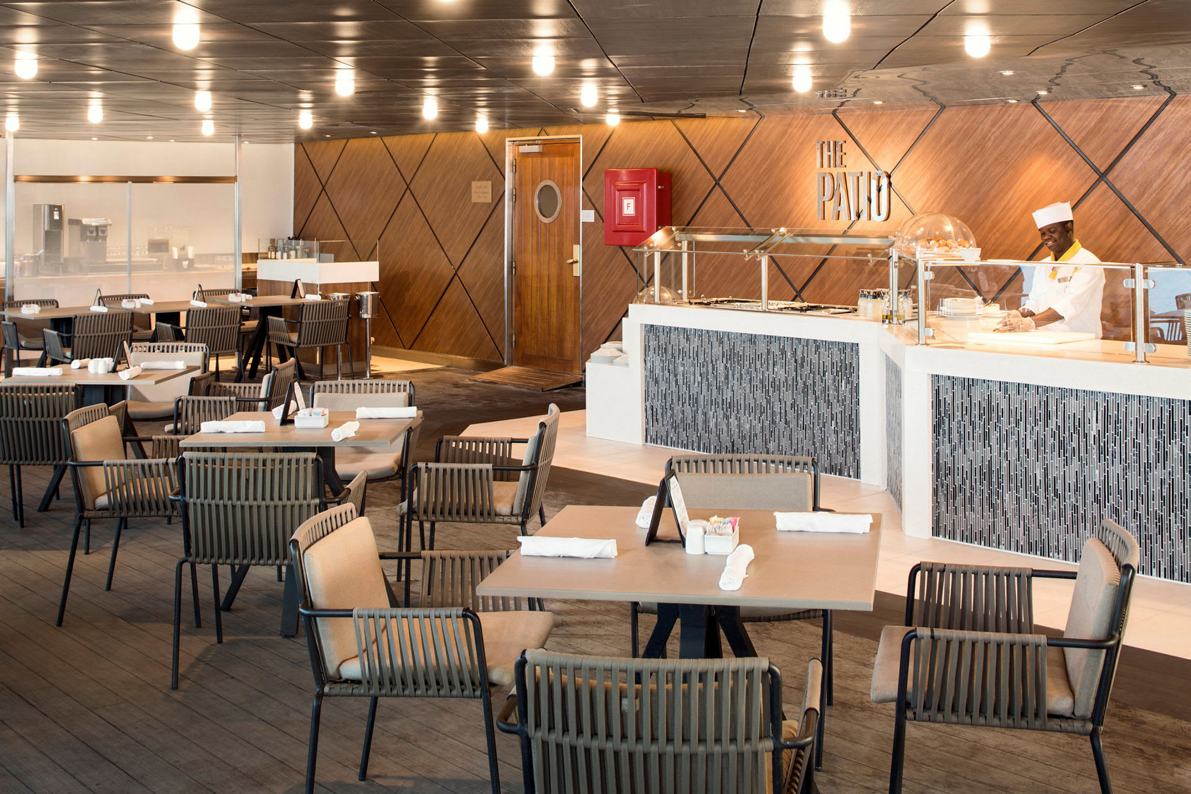 Restaurangmiljö med bord, stolar och serveringsdisk. (AI-genererad text)