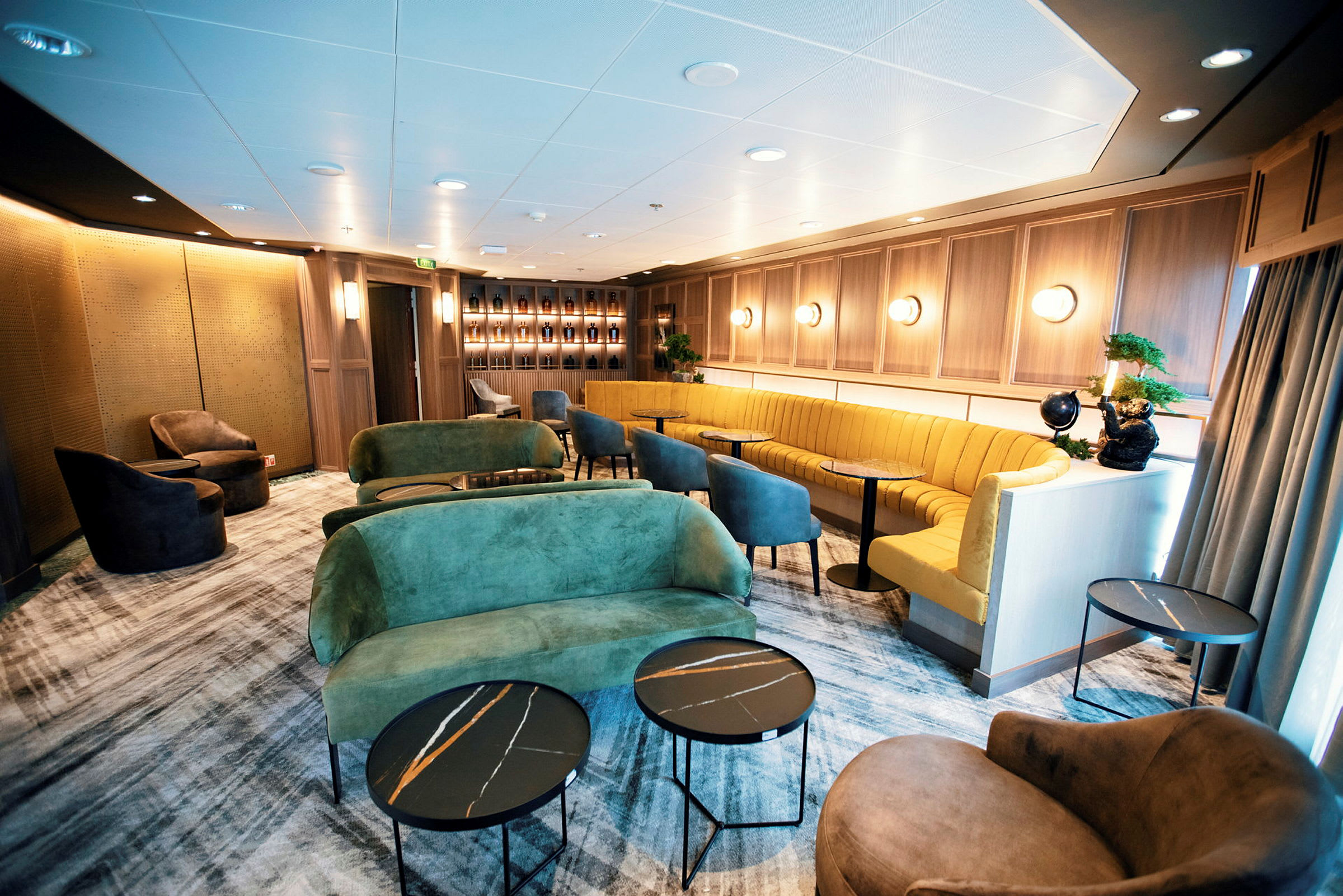 Ett elegant inrett rum med sittplatser, dekorerat med färgstarka soffor, fåtöljer och moderna bord. (AI-genererad text)