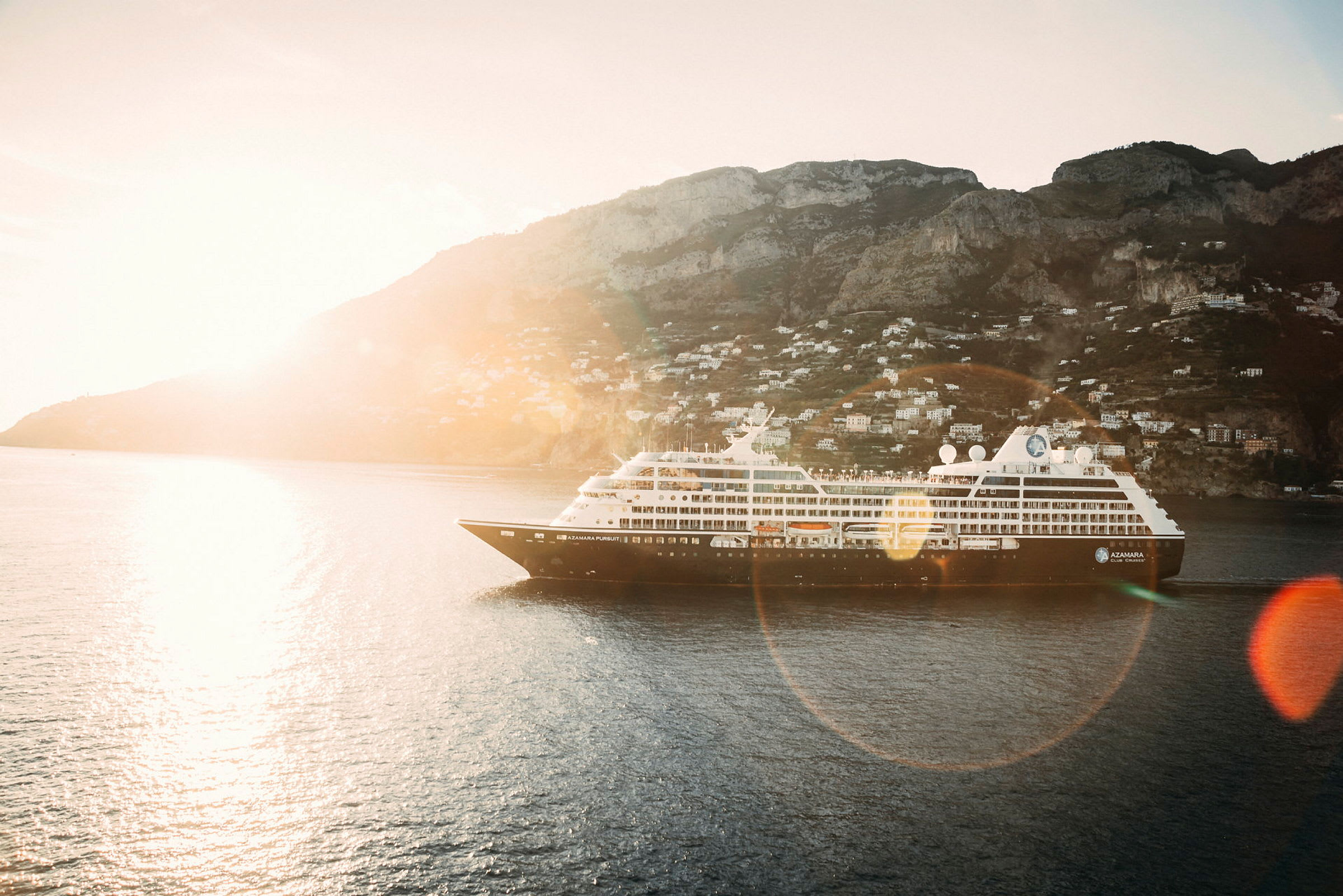 Ett kryssningsfartyg på vattnet med en bergig kust i bakgrunden. (AI-genererad text)