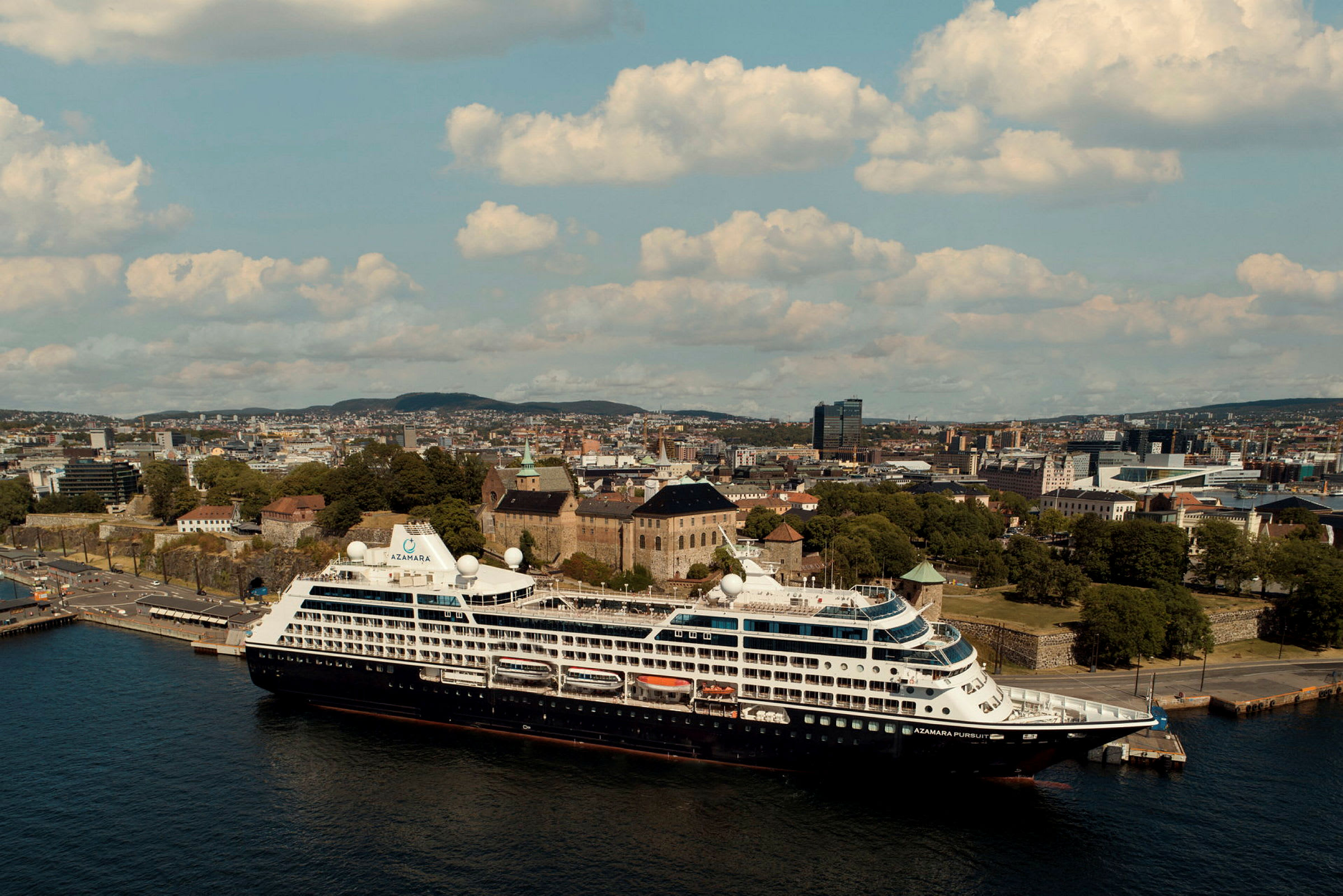 Kryssningsfartyg vid kaj med en stad i bakgrunden. (AI-genererad text)