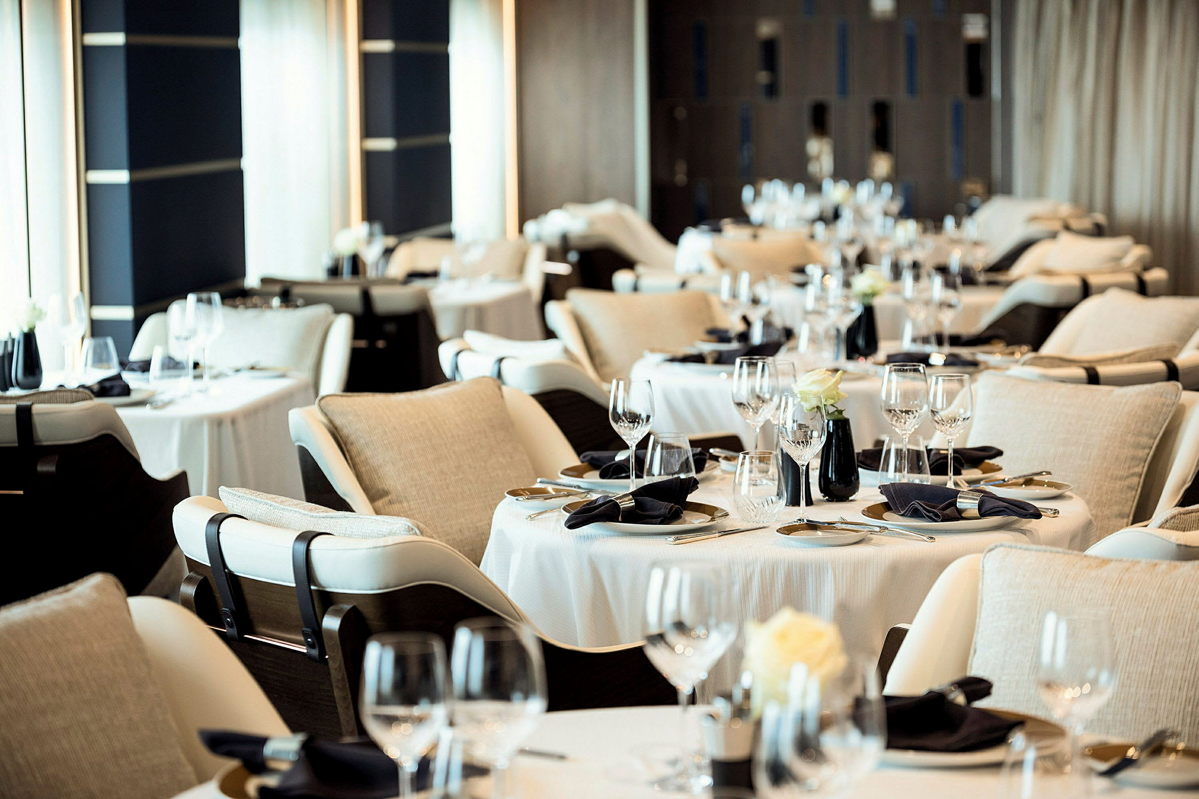 Bild av en elegant restaurang med dukade bord, stolar och dekorativa detaljer. (AI-genererad text)