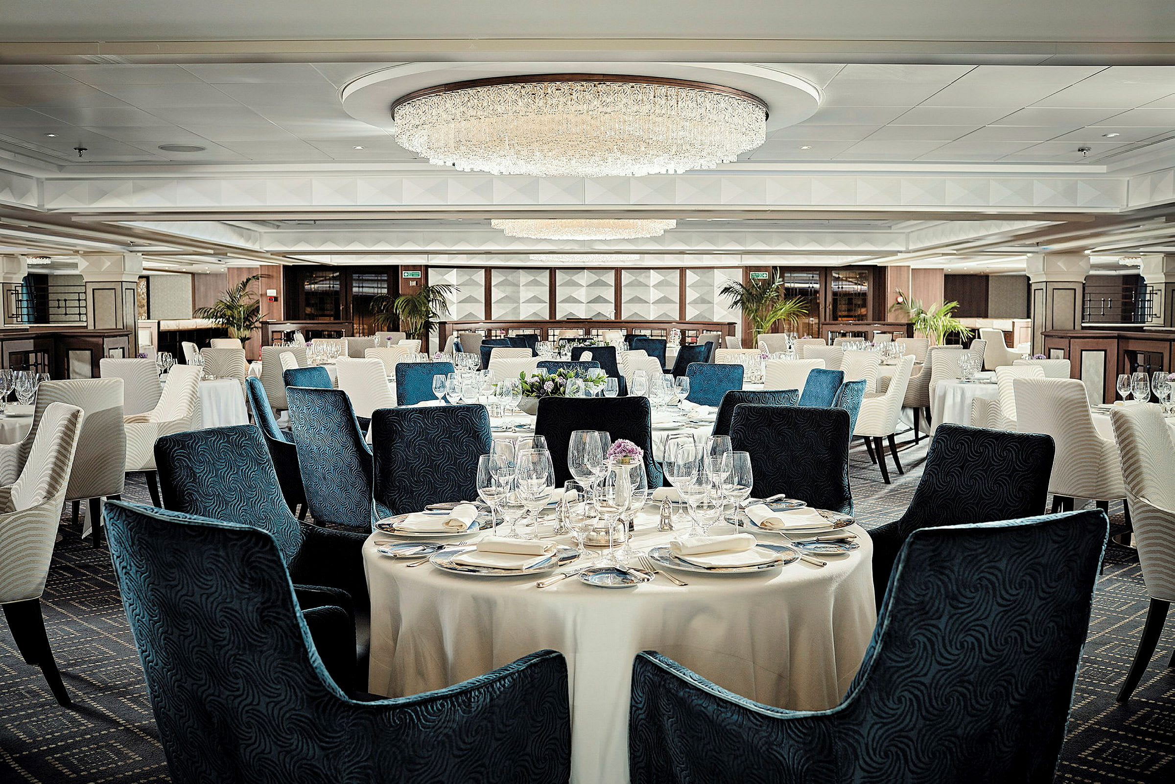 En elegant restaurang med dukade bord och blåa samt vita stolar. (AI-genererad text)