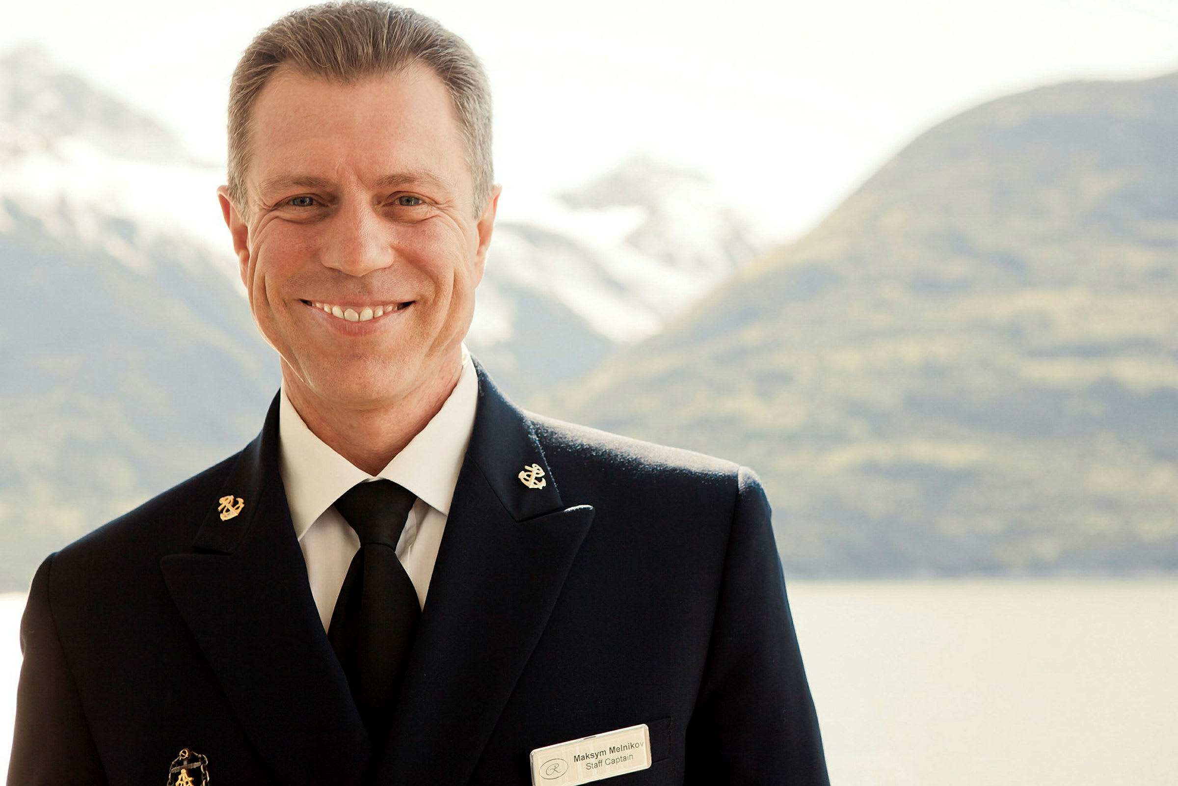 Person i uniform med berg och vatten i bakgrunden. (AI-genererad text)