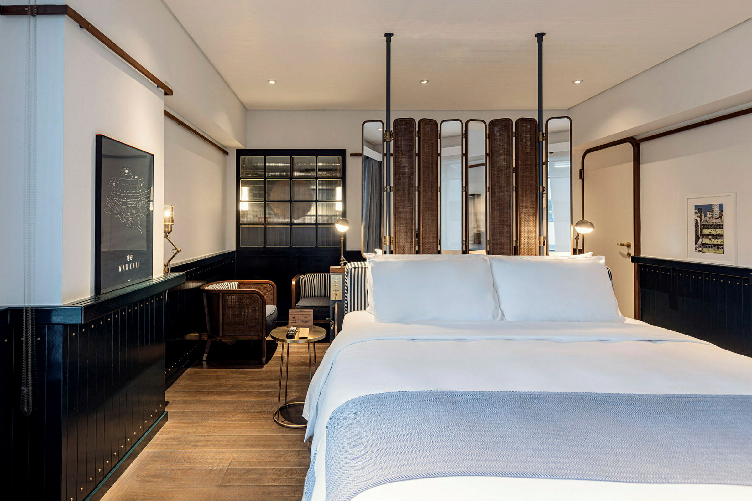 Modernt hotellrum med stor dubbelsäng och sittgrupp i bakgrunden. (AI-genererad text)