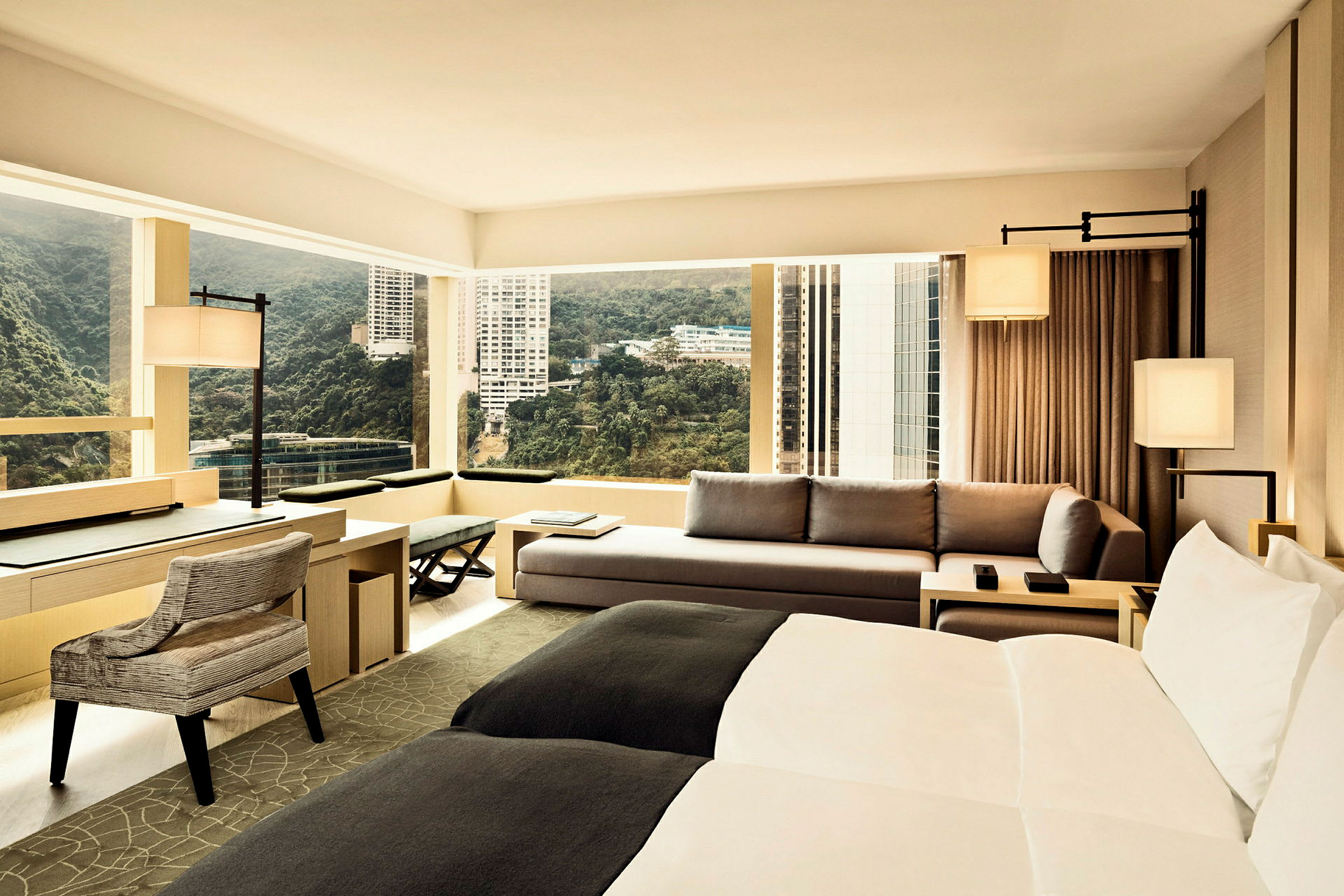 Hotellrum med modern inredning, stora fönster och utsikt över staden. (AI-genererad text)