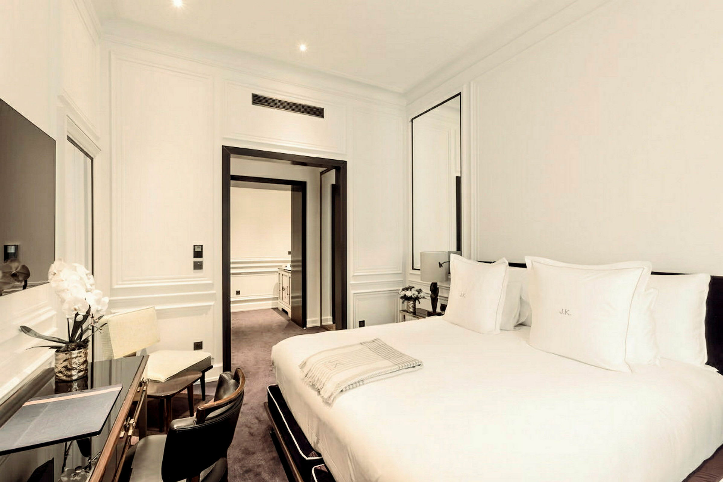 Ett elegant hotellrum med en stor dubbelsäng och en arbetsyta. (AI-genererad text)
