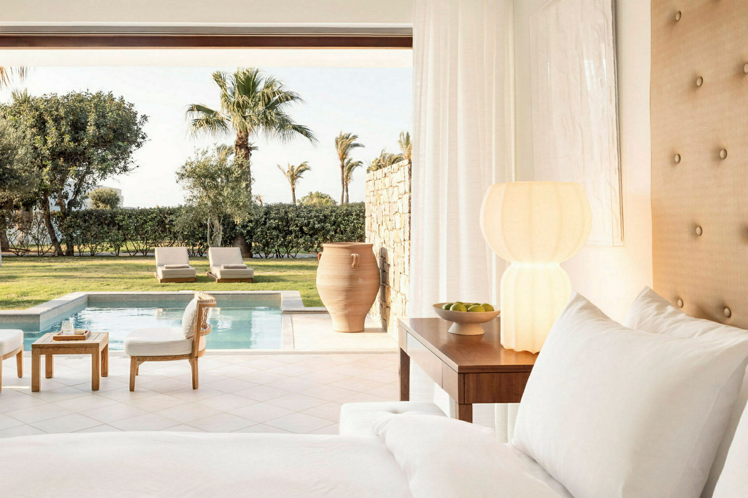 Hotellrum med utsikt över pool och grönyta. (AI-genererad text)