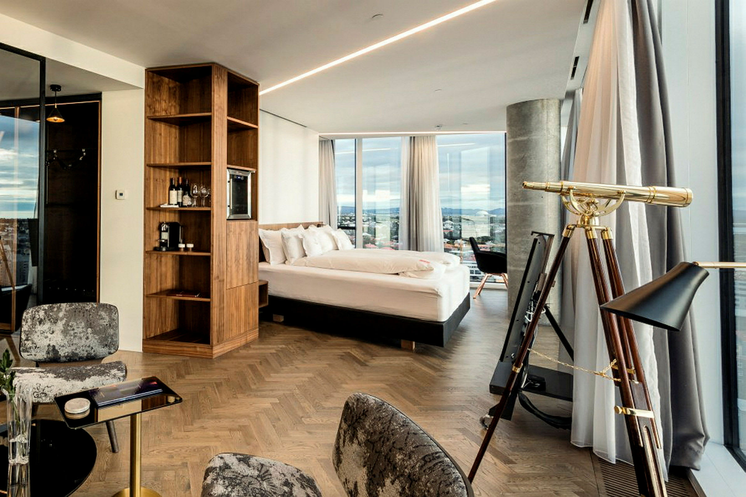 Bild på ett moderna hotellrum med stor säng, teleskop och panoramafönster. (AI-genererad text)