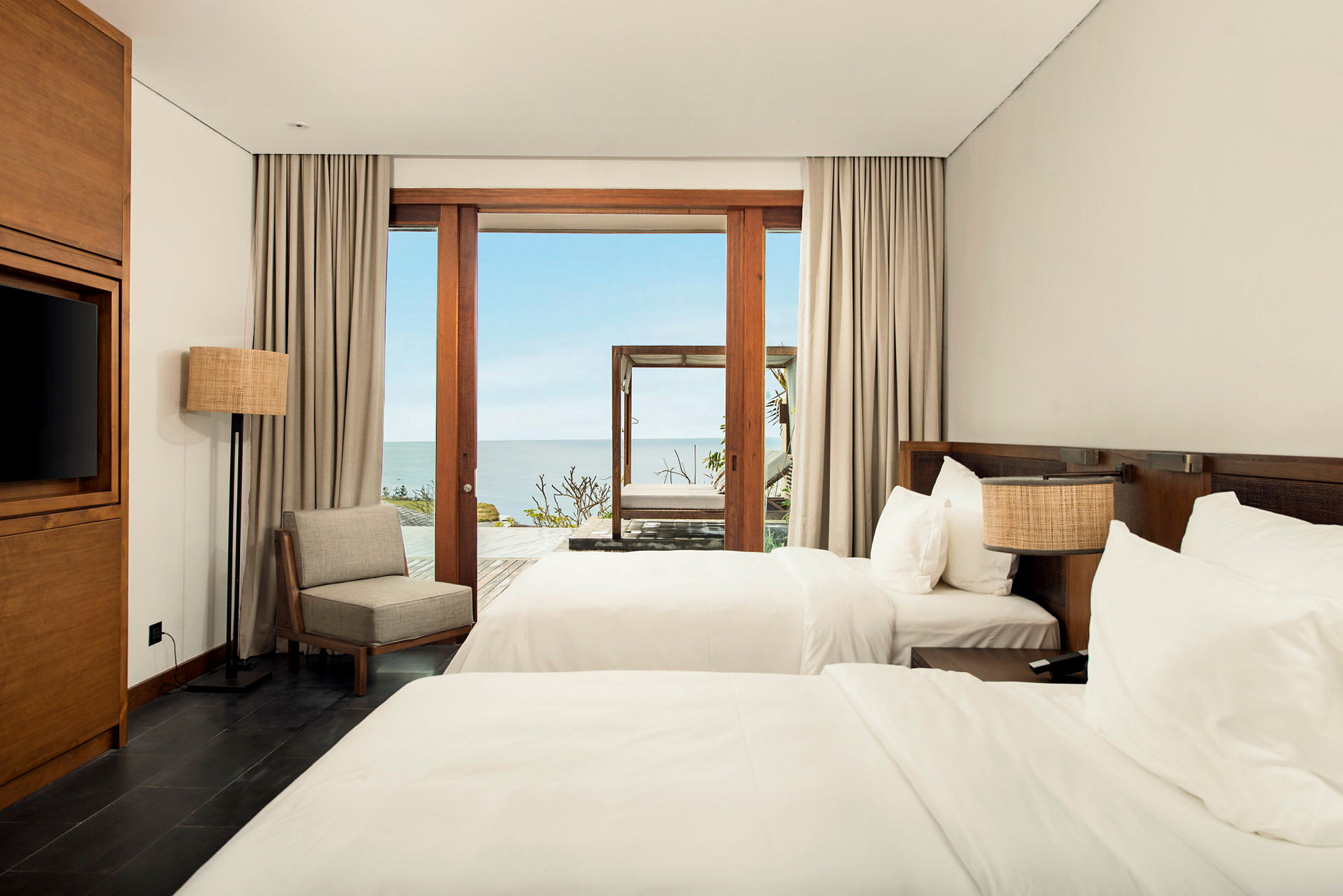 Ett hotellrum med två sängar och ett fönster som vetter mot havet. (AI-genererad text)