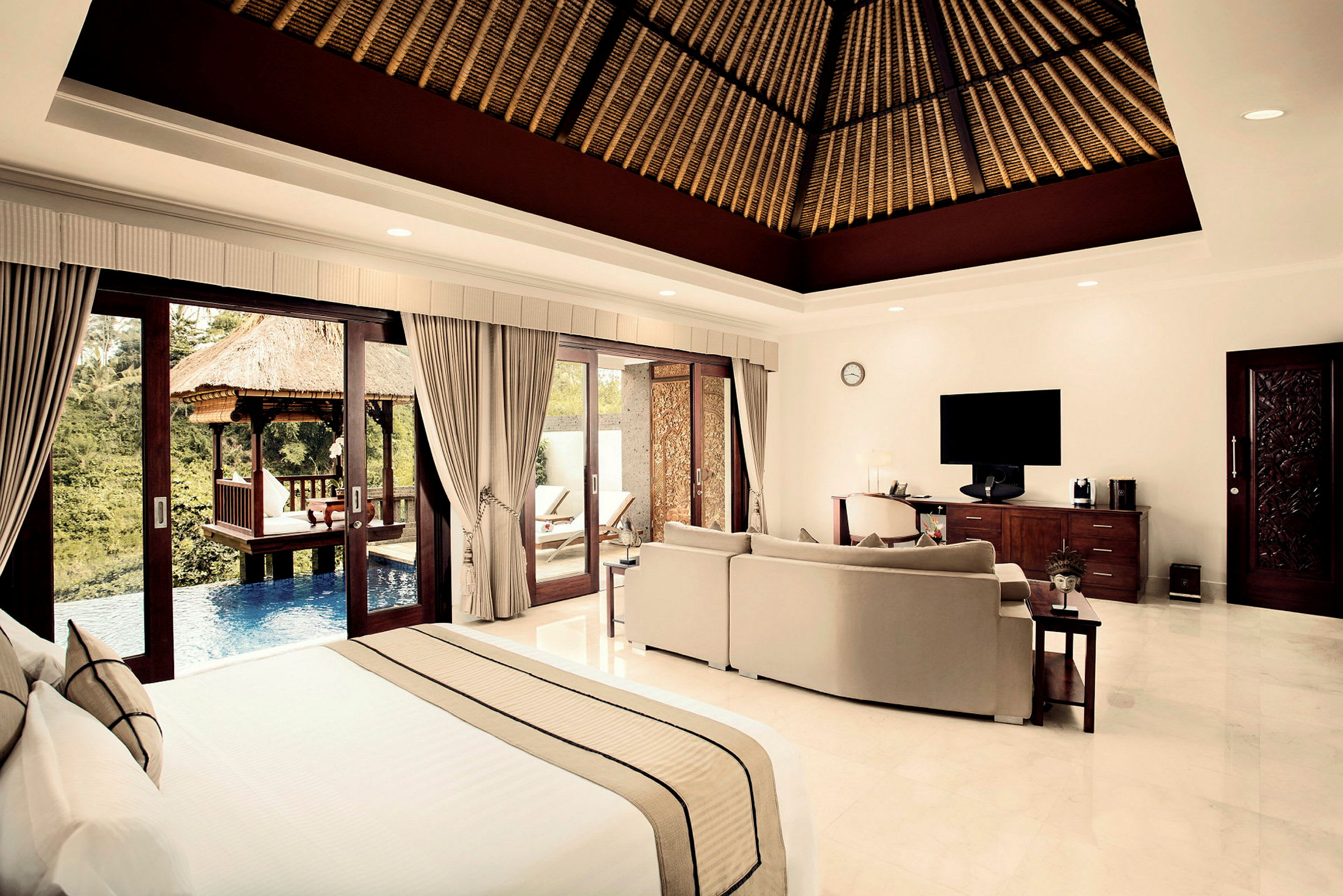 Bild av ett elegant hotellrum med stora fönster mot en privat pool och grönska. (AI-genererad text)