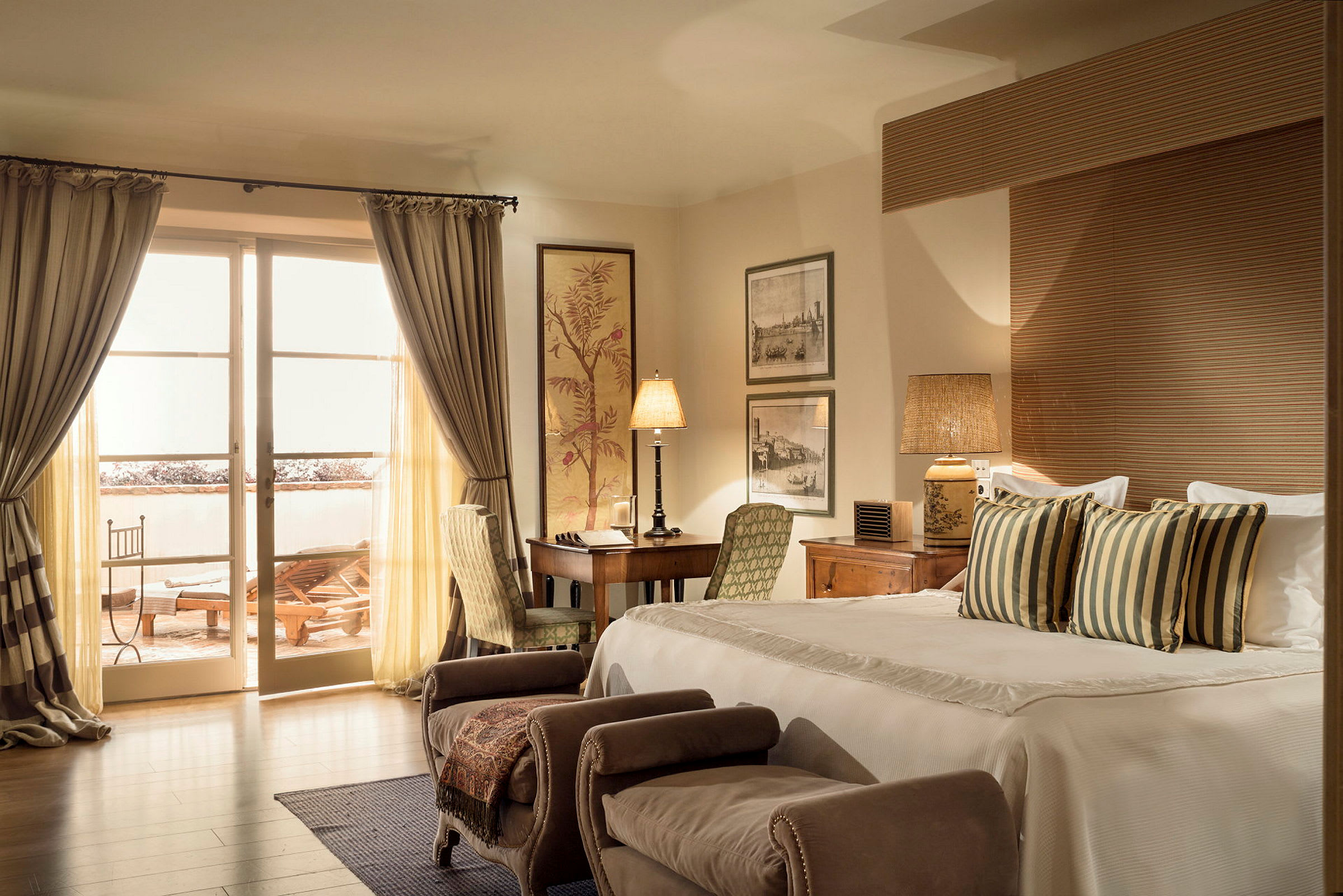 Ett hotellrum med en bekväm dubbelsäng, sittmöbler och skrivbord. Ett stort fönster med gardiner leder ut till en möblerad balkong. (AI-genererad text)