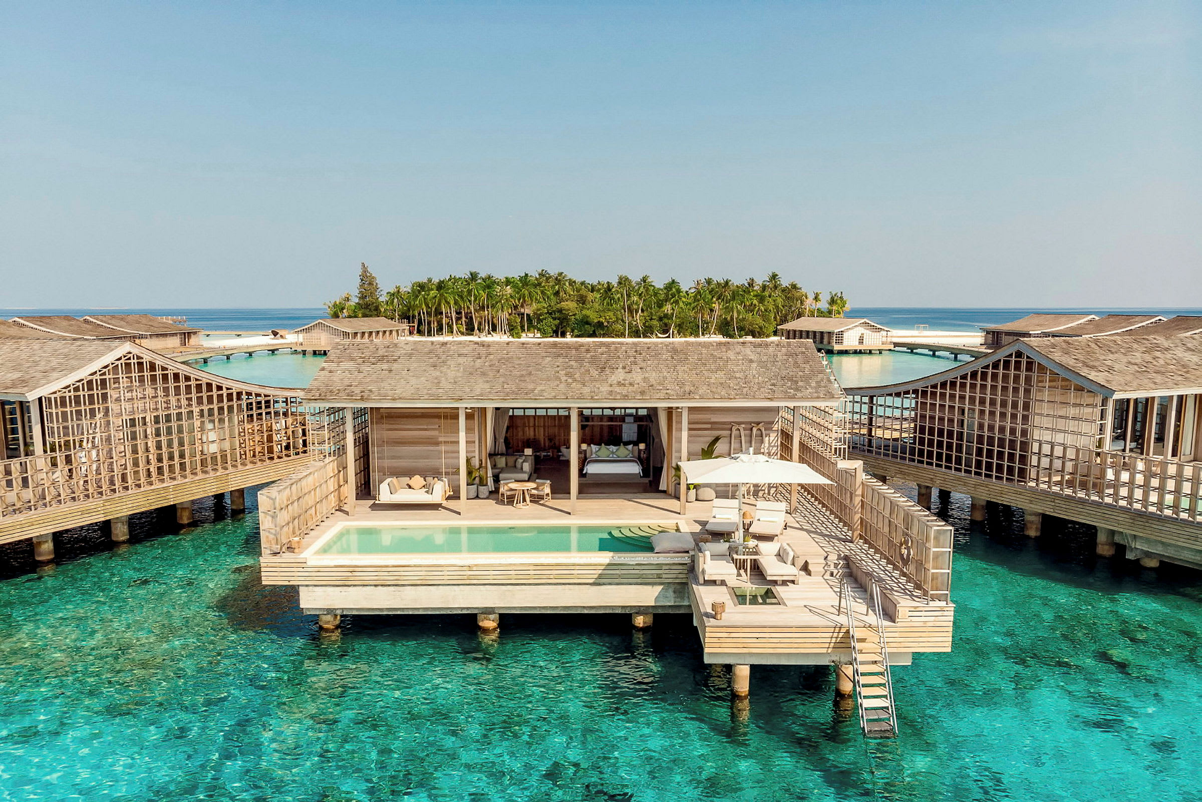 Lyxig villa över vattnet med privat pool och terrass, omgiven av turkost hav. (AI-genererad text)
