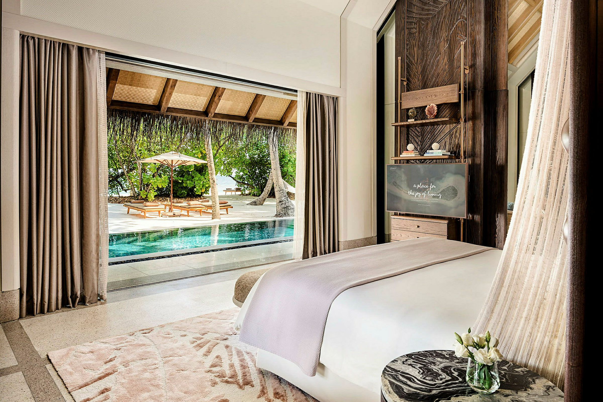 Hotellrum med utsikt över en pool och utomhusområde med solmöbler. (AI-genererad text)