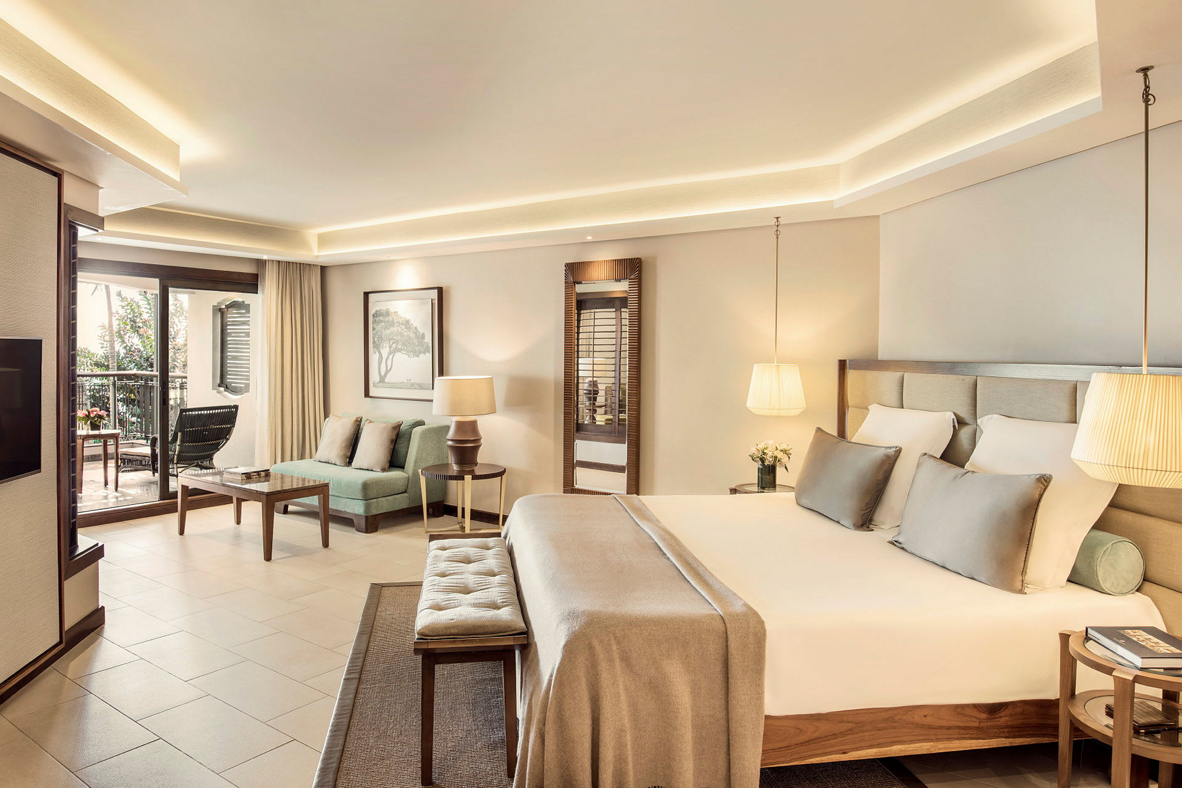 Ett elegant hotellrum med en stor säng och sittgrupp, samt en balkong med utsikt. (AI-genererad text)