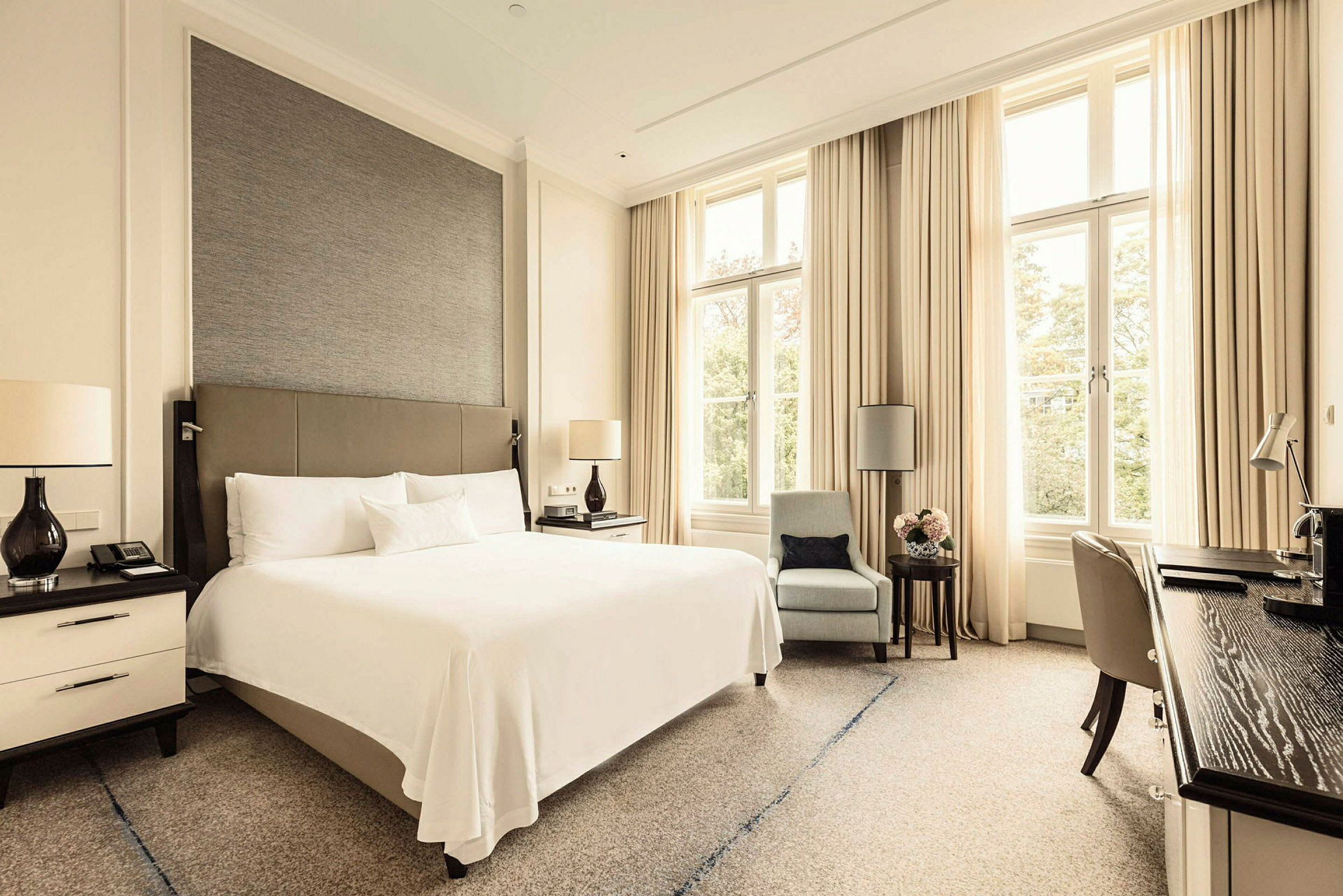Ett hotellrum med en dubbelsäng och stora fönster. (AI-genererad text)