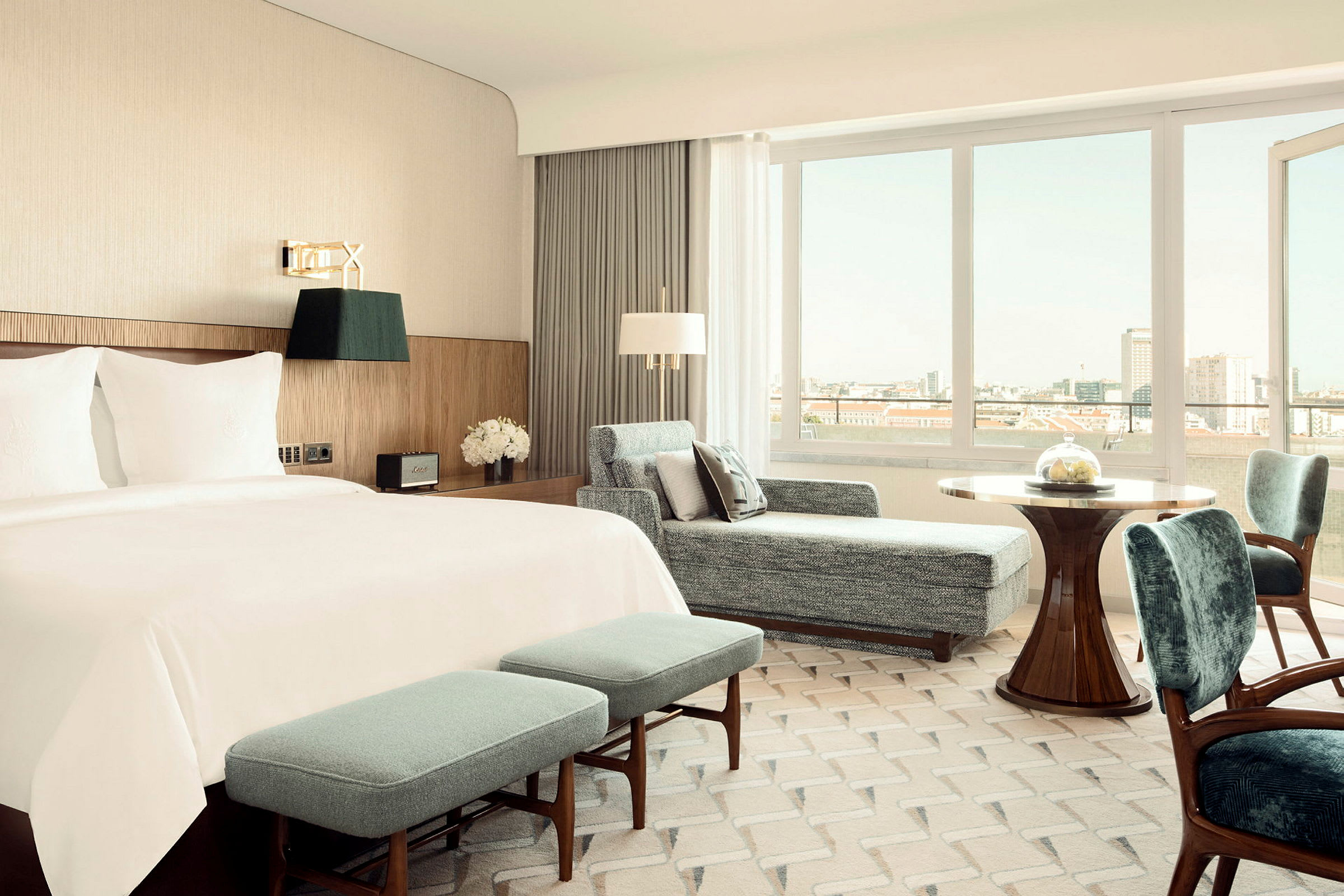 Ett elegant hotellrum med en stor säng, sittmöbler och fönster med utsikt. (AI-genererad text)