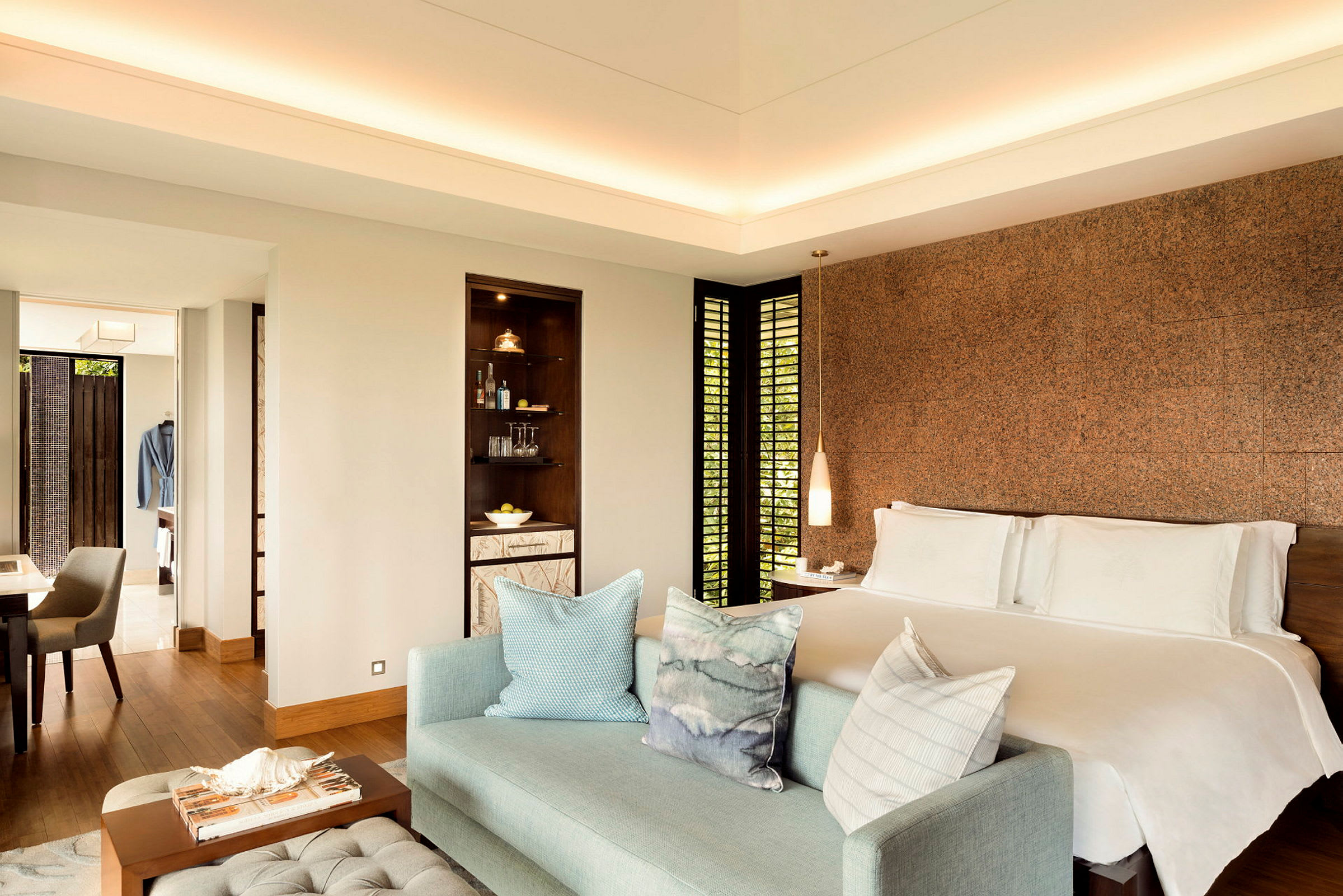 Ett elegant hotellrum med en dubbelsäng, soffa och ett bord framför. (AI-genererad text)