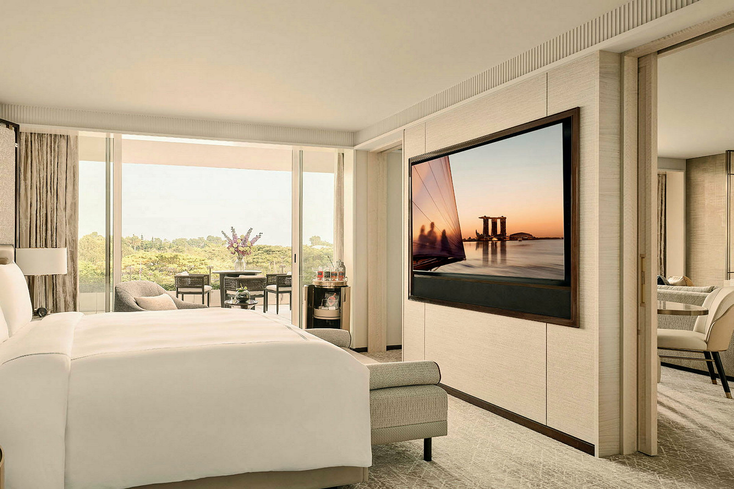 Ett modernt hotellrum med en säng, en stor TV och en balkong med utsikt. (AI-genererad text)