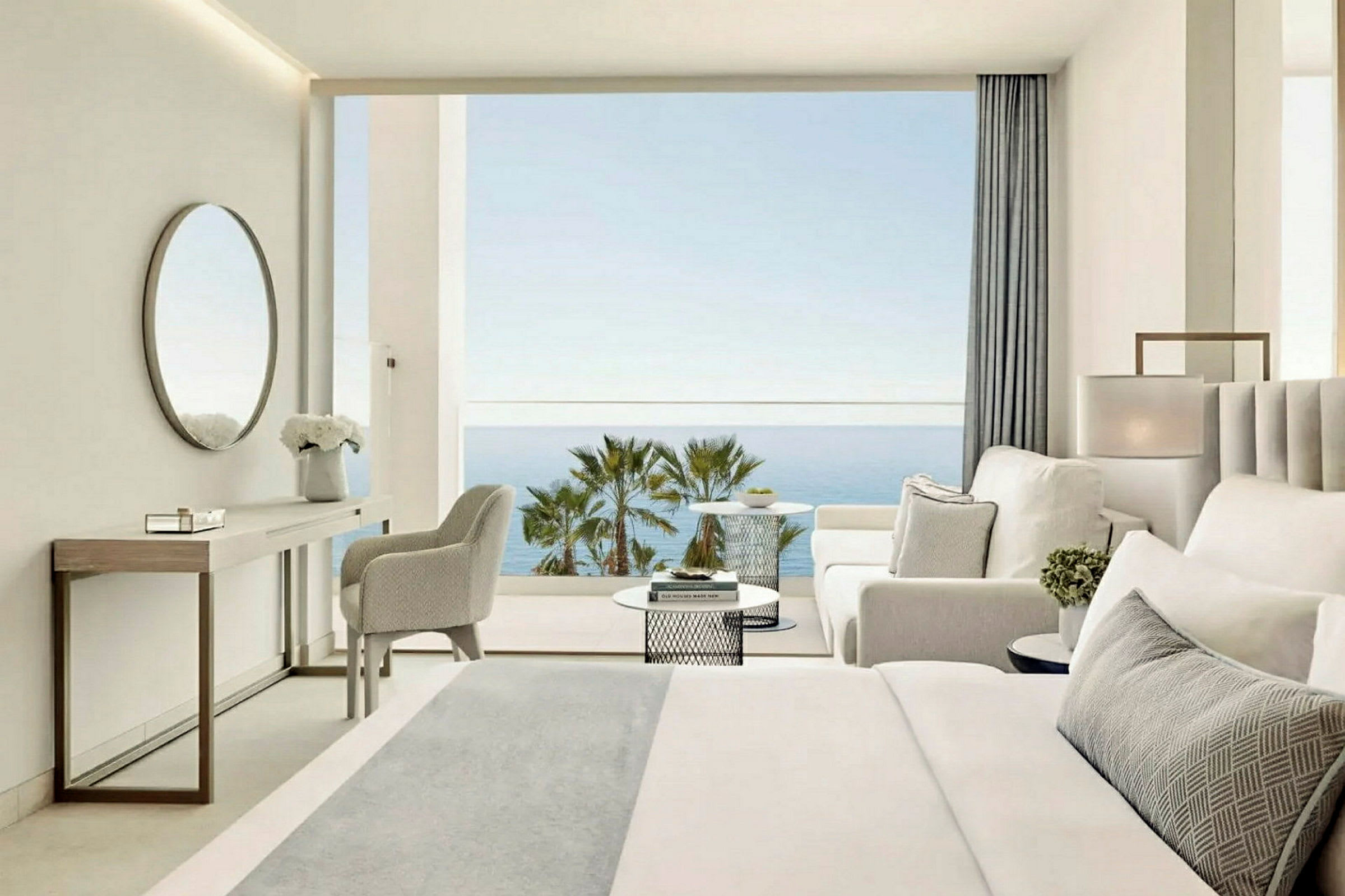 Ett hotellrum med modern inredning som har utsikt över havet och palmer. (AI-genererad text)