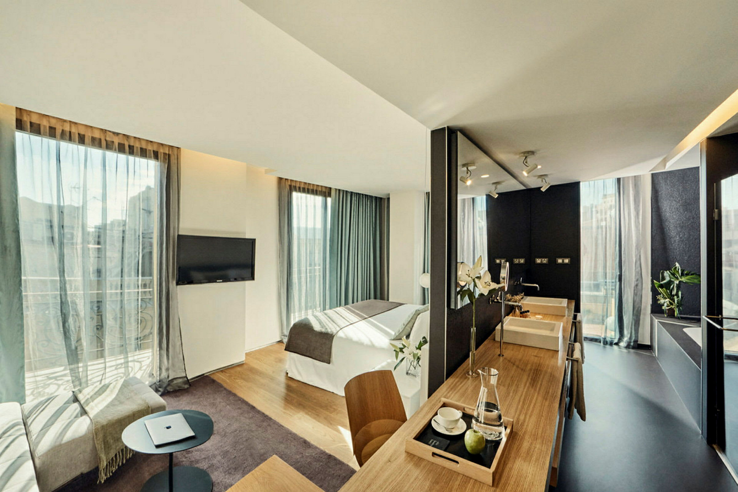 Modernt hotellrum med dubbelbädd, sittplats och ett litet köksområde. (AI-genererad text)