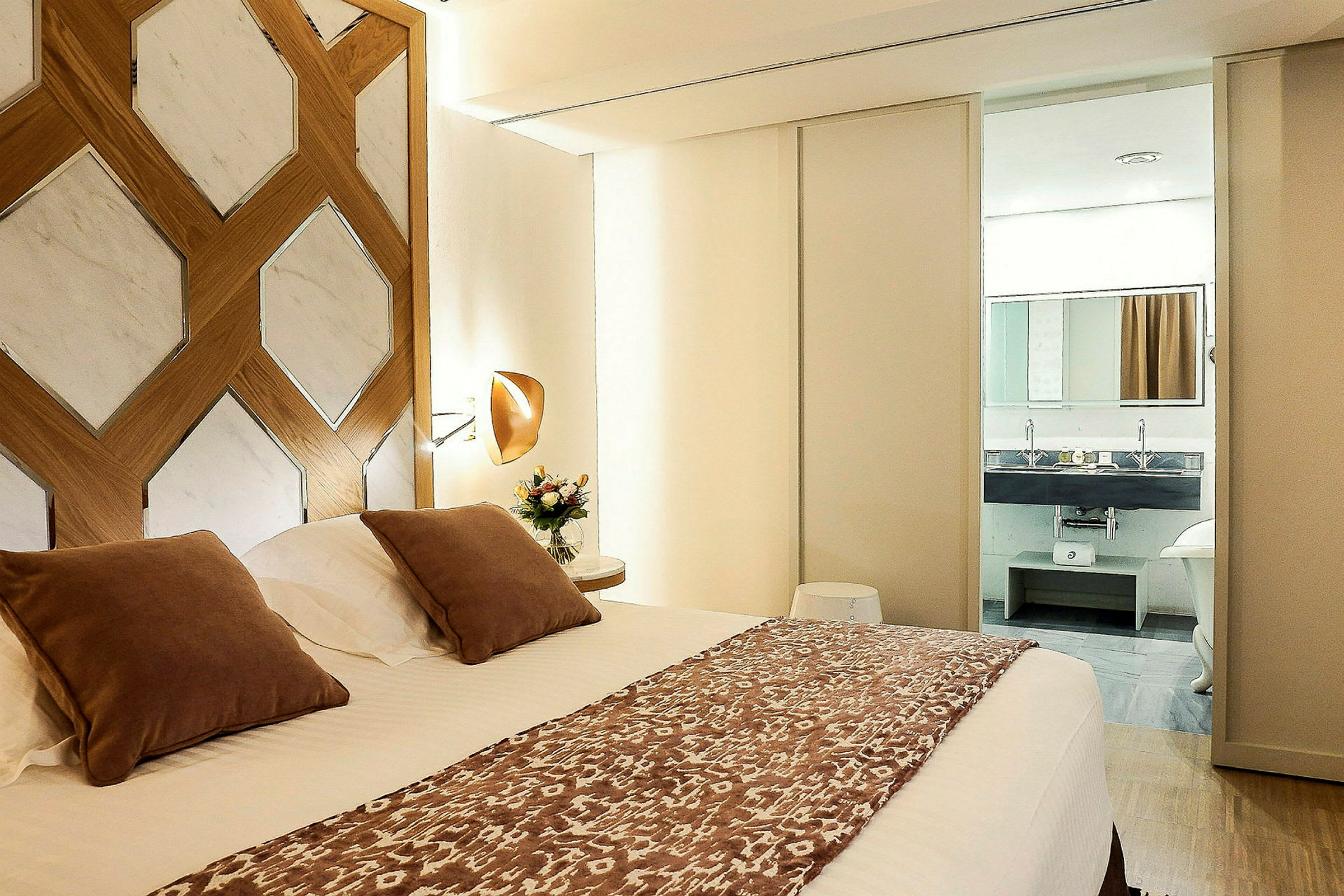 Modern hotellrum med dubbelsäng och utsikt mot badrum. (AI-genererad text)