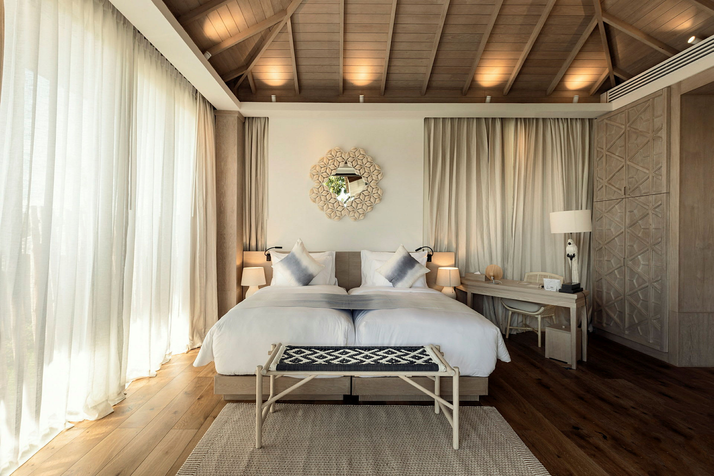 Bild av ett ljus och elegant hotellrum med en dubbelsäng, skrivbord och dekorativa detaljer. (AI-genererad text)