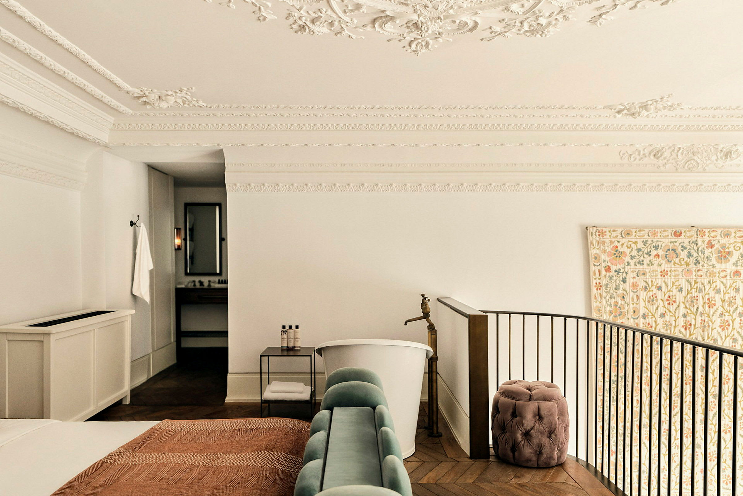 Ett elegant hotellrum med vitt dekorativt tak, fristående badkar och trappa. (AI-genererad text)