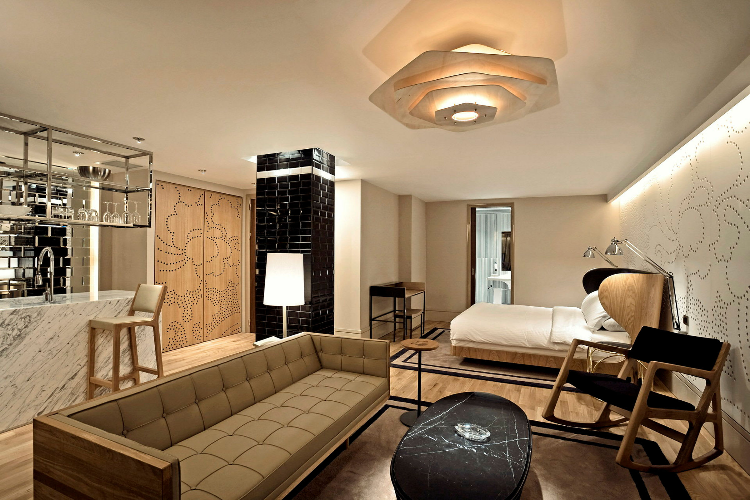 Ett hotellrum med modern inredning, inklusive en säng, soffa, och bord. (AI-genererad text)