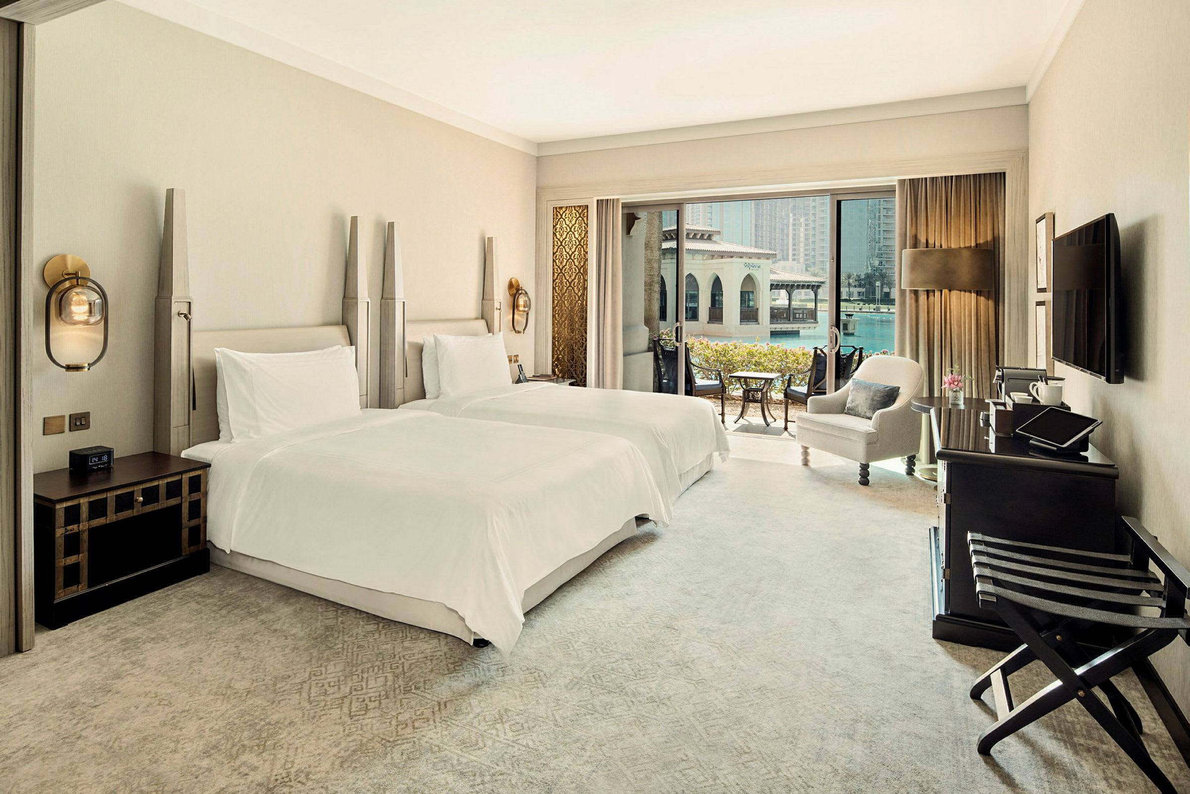 Hotellrum med två enkelsängar, sittgrupp och balkong med utsikt. (AI-genererad text)