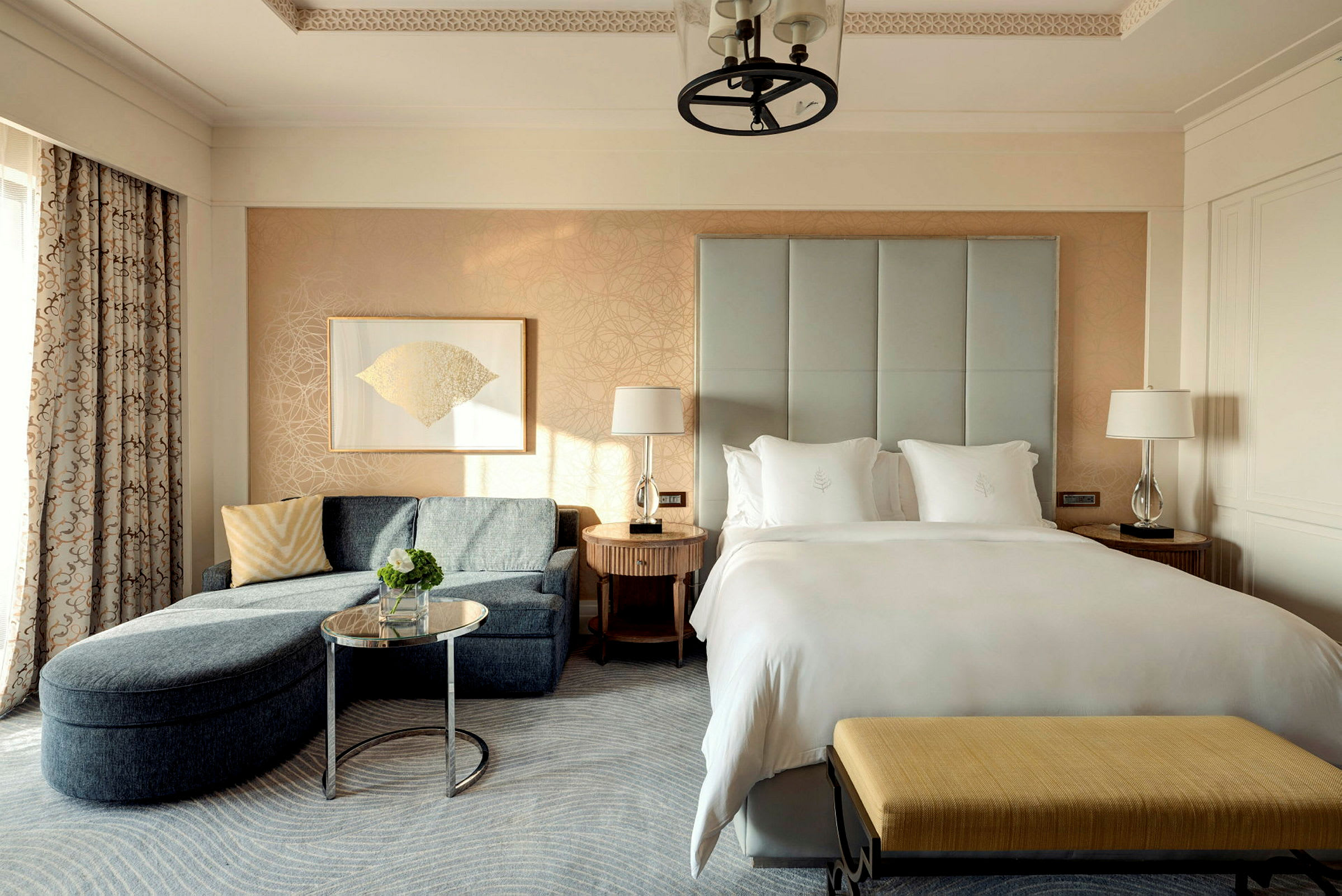 Ett hotellrum med en säng, en soffa och en liten soffbänk. (AI-genererad text)