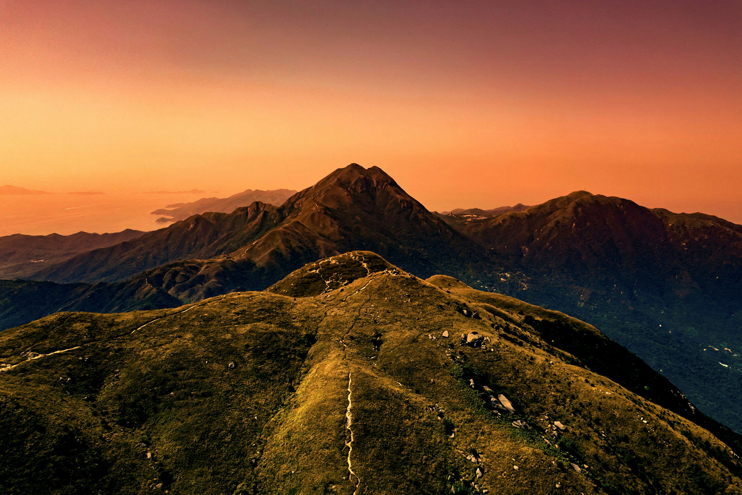 Berglandskap under en orange himmel vid solnedgång. (AI-genererad text)