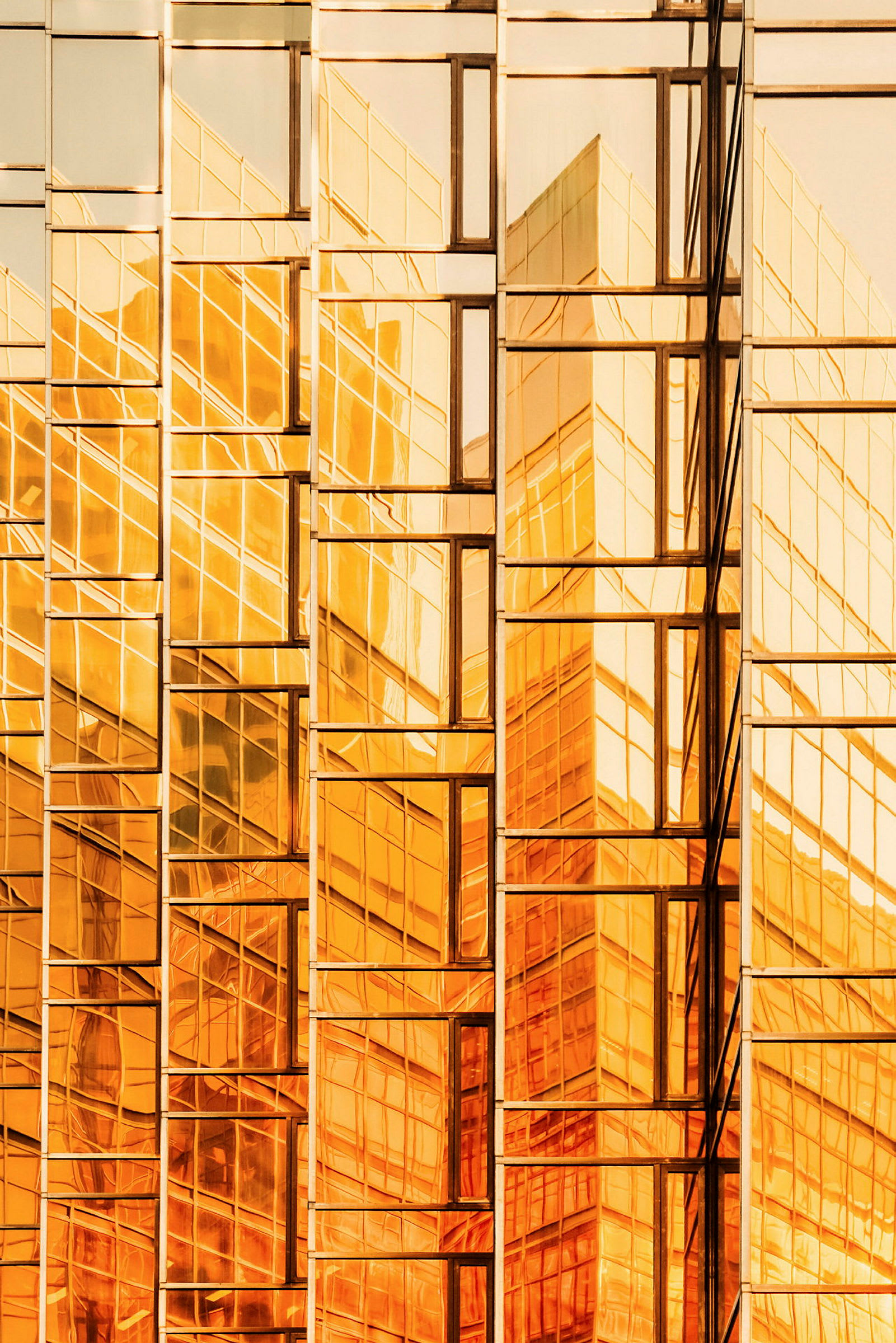 En glasfasad med reflektioner i guldtoner. (AI-genererad text)