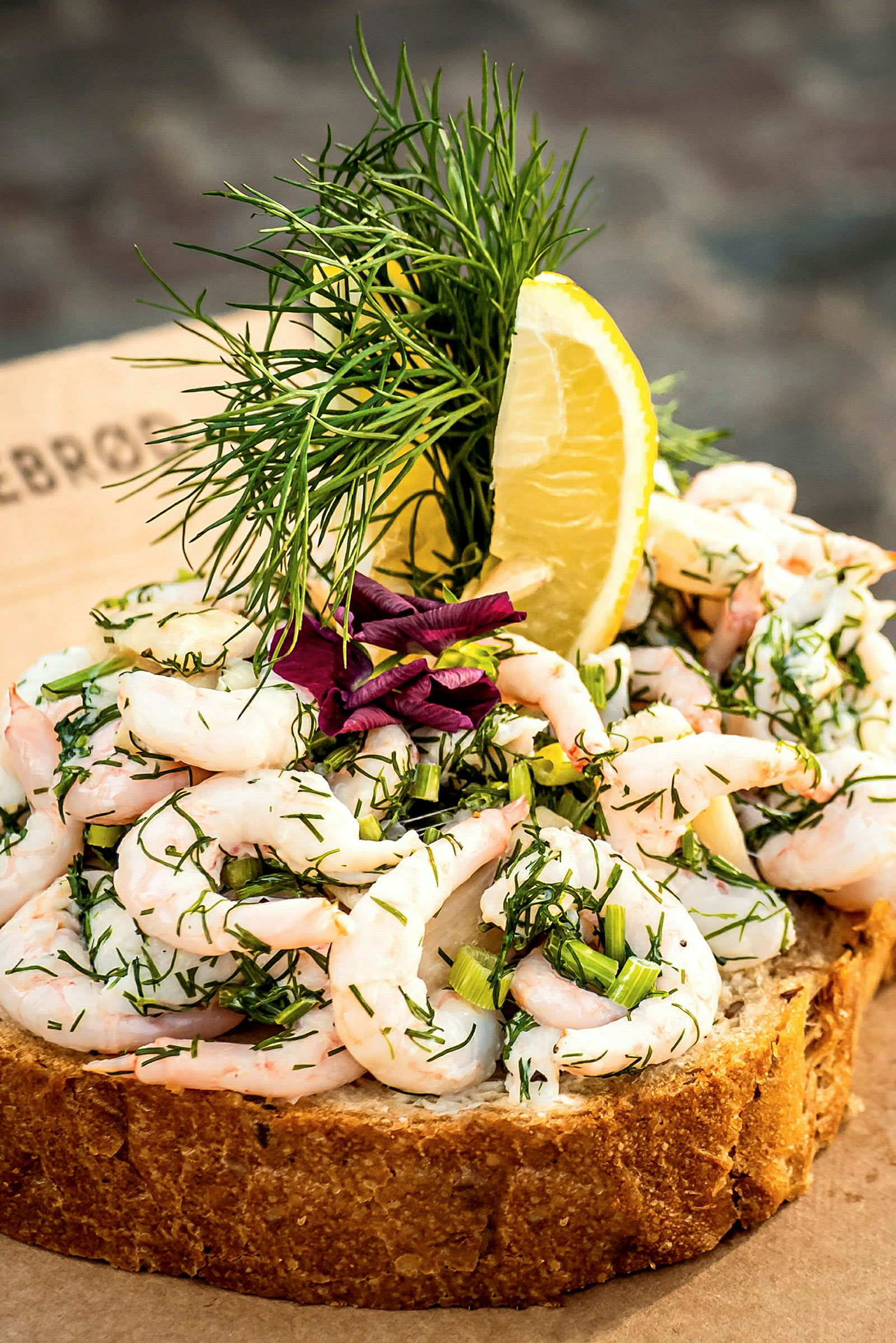 Close-up av en räksmörgås med dill, citron och rödlök. (AI-genererad text)